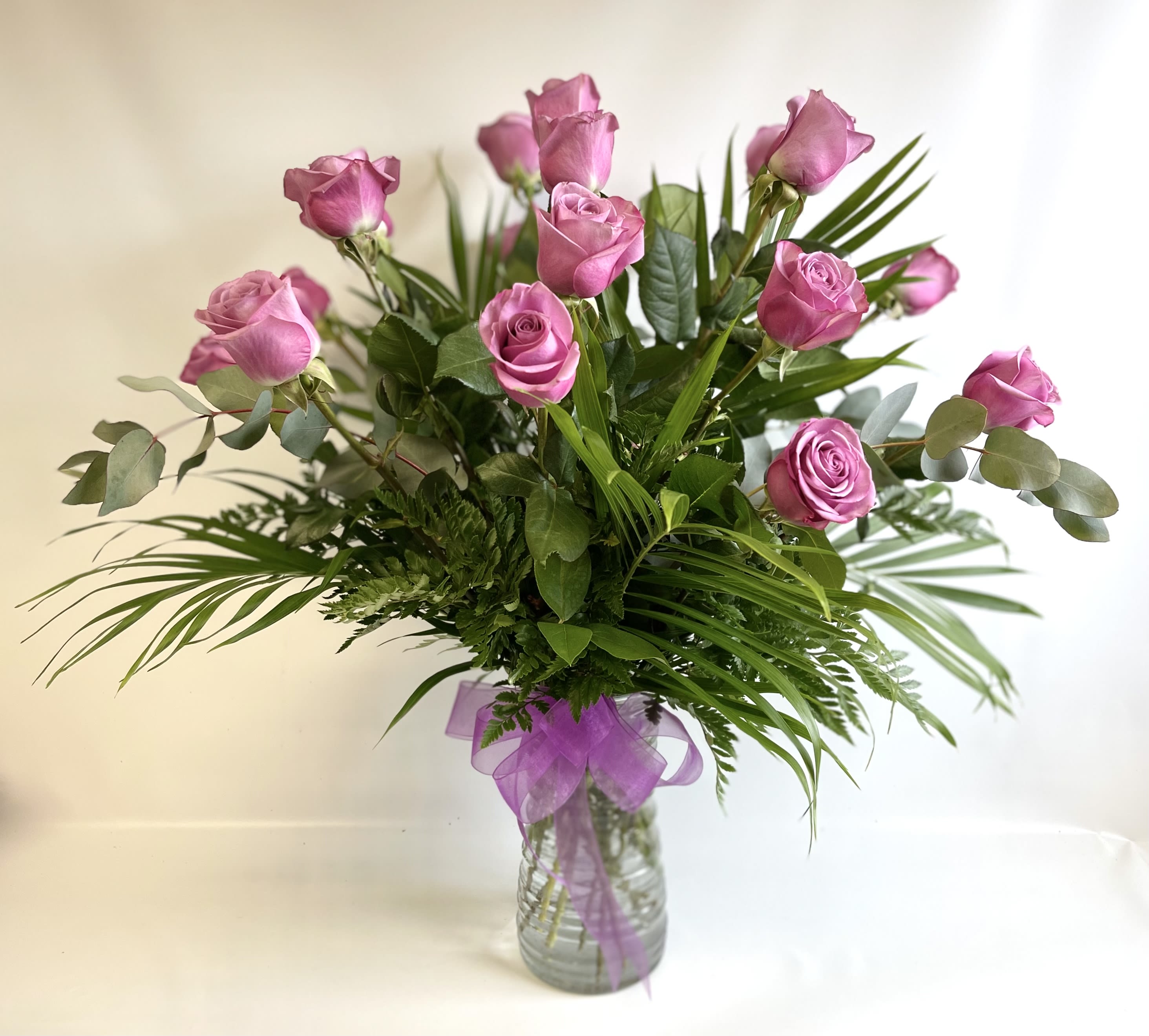 18 Lavender Roses by Barb’s Flowers - 18 Lavender Roses beautifully arranged in a vase. PREMIUM includes higher end fillers and foliage. 