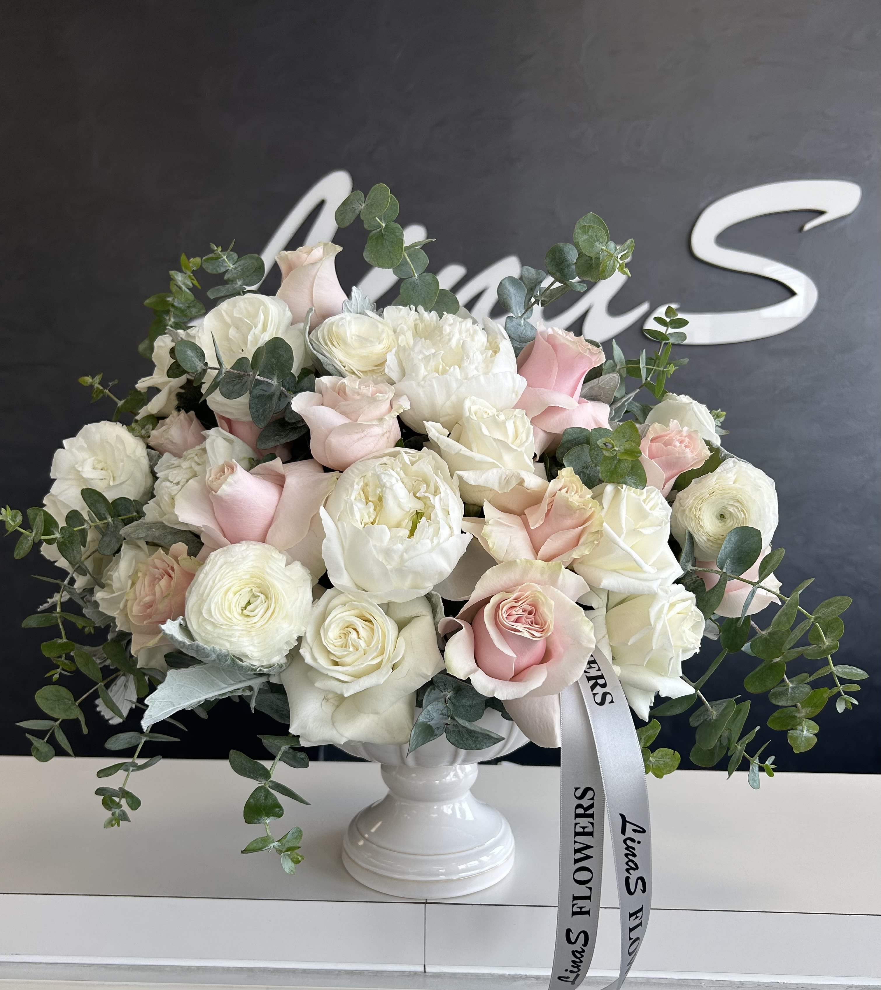 Mumu Mumu - A sophisticated arrangement of white peonies and roses, showcasing the elegant blend of lush peony blooms and classic roses in a pure, timeless white. Perfect for weddings or any elegant occasion.