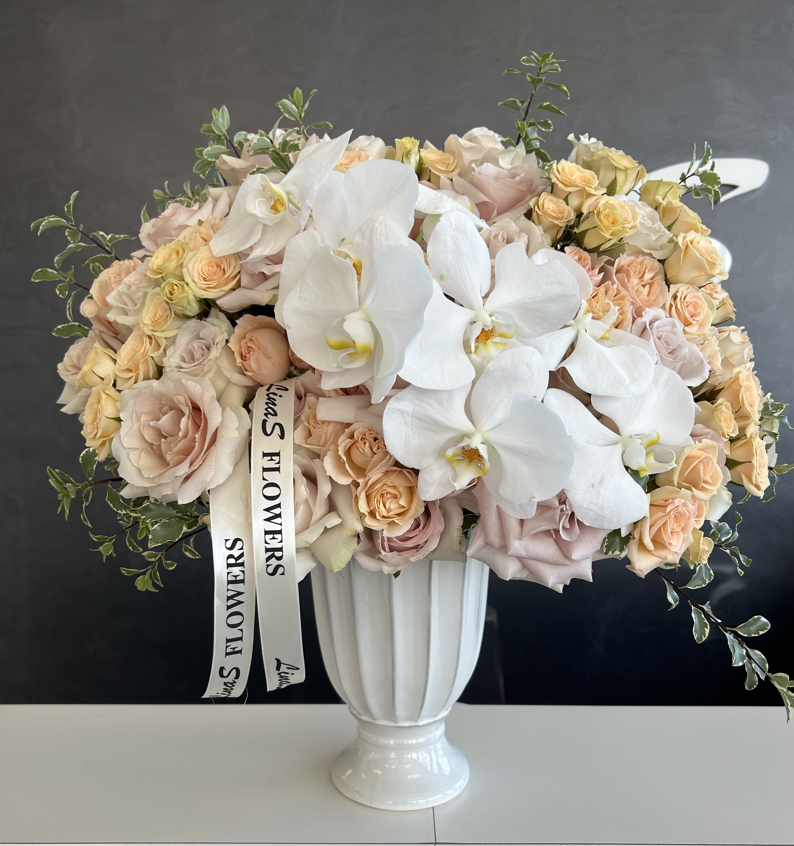 Liza Liza - A beautiful phalaenopsis arrangement, featuring the elegant, long-lasting blooms of phalaenopsis orchids. With their graceful shape and vibrant colors, this arrangement adds a touch of sophistication and luxury to any space or occasion.