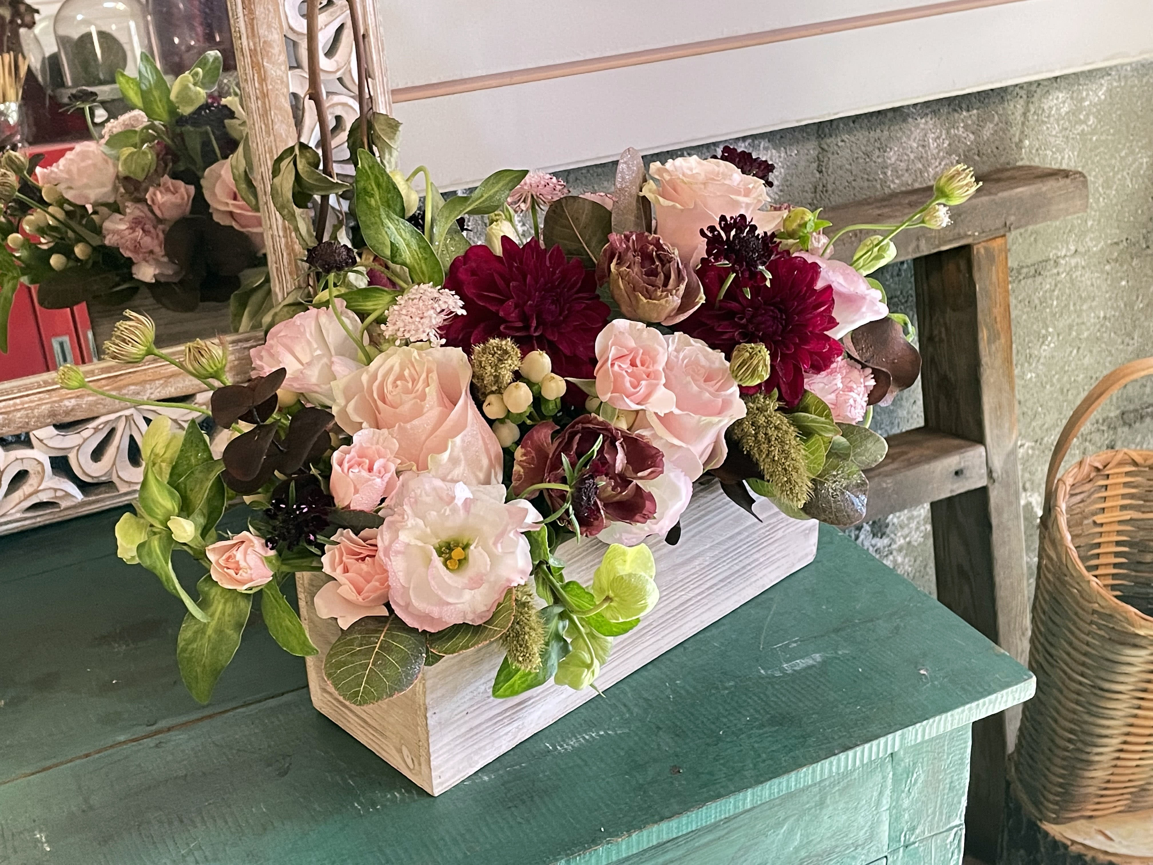 Luna  - Introducing Luna, the ultimate fall floral experience that will leave you speechless! Imagine a stunning box filled with a vibrant blend of pink and burgundy flowers, meticulously handpicked to give your space a cozy autumn touch. Whether you want to impress your loved ones or simply treat yourself, Luna is the perfect gift that captures the essence of fall in every petal. Hurry and bring home Luna today to elevate your floral game to new heights!  Arranged in a 4x12 long wooden rectangle box. Approximately 14&quot; long by 5&quot; wide.   Features dahlias, pink Mondial roses, hellebore, spray roses, lisianthus, dried flowers, and seasonal greenery. 