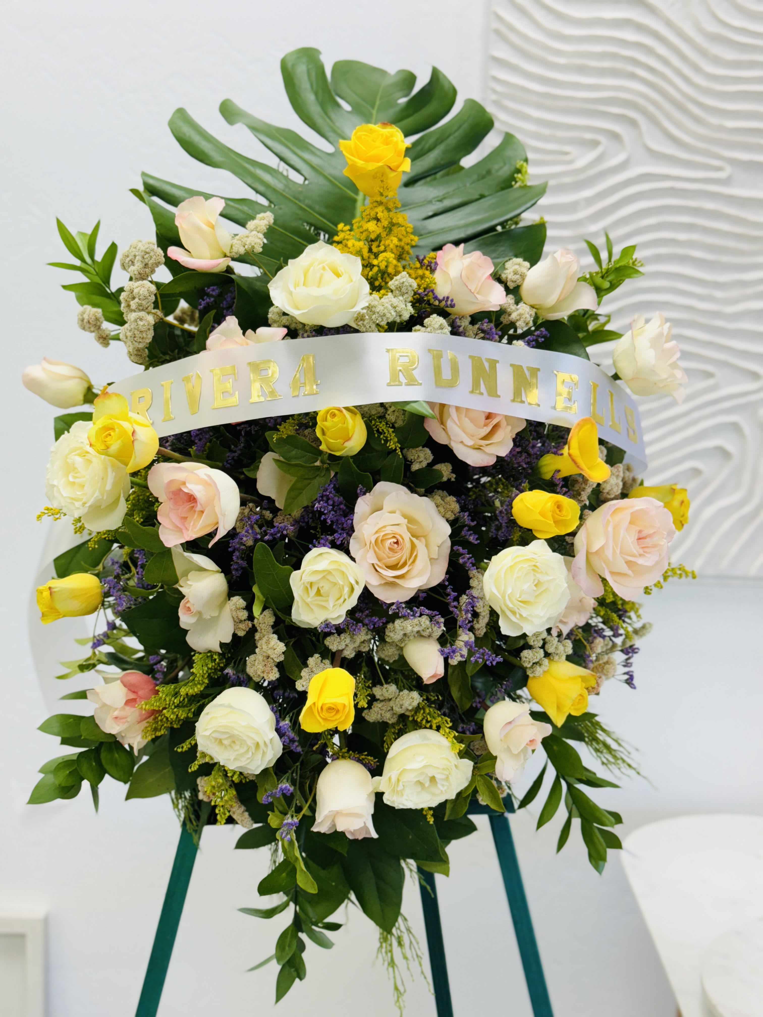 Funeral Standing Spray Yellow and White  - A vibrant and uplifting tribute that celebrates the life of a loved one! (The photo represents a medium sized spray)  Fulfill your floral needs at I Am Clover in Ramona, CA, and experience the difference in quality, freshness, and care that comes with ordering locally.   Disclosure: Occasional substitutions of flowers happen due to weather, seasonality and market conditions. We will ensure that the style, theme and color scheme of your arrangement is preserved and will only substitute items of equal value or higher value.  Delivery: 2:30pm - 6:30pm Same Day Orders may take at least 6 hours to process and deliver Morning and Specific Delivery Time Requests:  will be charged a $15 convenience fee. Specific delivery times are acknowledged and we will do our best to accommodate, however we cannot guarantee on time delivery due to unforeseen events.  Gate Codes are mandatory for our delivery drivers to enter residential or commercial buildings. If you don’t know the gate code for a delivery, please contact the recipient and provide us with it or our driver can contact the recipient before beginning a delivery route to obtain the code. Our drivers will only wait five minutes outside the gate for a callback. If a driver has to leave a property, the delivery is reassigned for the next day and may charge an additional delivery fee.   Thank you!