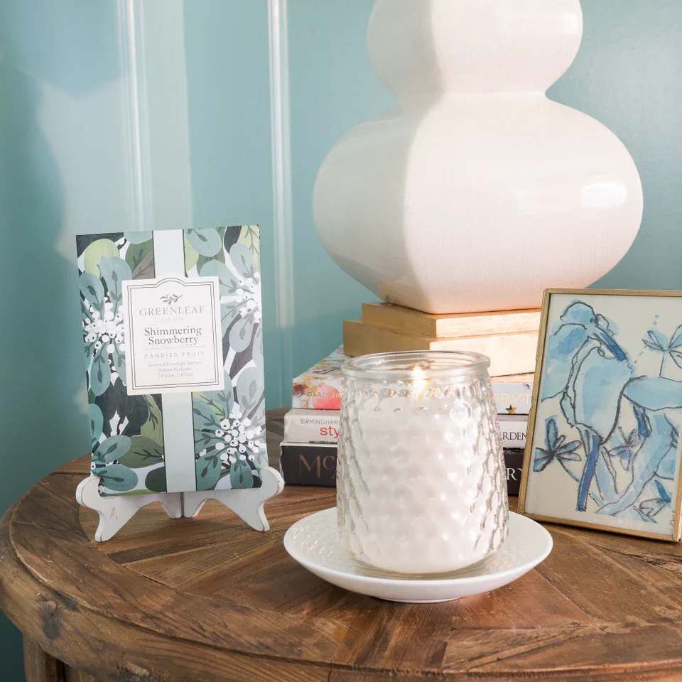 Shimmering Snowberry Candle Shimmering Snowberry Candle - With a clear, glass hobnail textured jar and a silver lid, our Signature Candle is the perfect match for any style. Fill your home with inviting Greenleaf fragrances that make any space feel cozy! What Makes it Special: Beautiful fragrance created in-house by a team of professional perfumers Fragrance: Shimmering Snowberry Fragrance Family: Fruit & Vine Fragrance Description: Glistening with modernity, Shimmering Snowberry juxtaposes a tart glaze of grapefruit, apple and kiwi with fresh-cut bouquets of sweet jasmine and lily. Use and Care: Burn within sight, Always trim wick to 1/4 in before lighting candle Keep candle on a level surface away from drafts Allow the wax to pool to the edge of the glass before extinguishing the flame Avoid dropping debris, such as wick trimmings, into the wax Extinguish the candle when your wax level reaches 1/4 inch