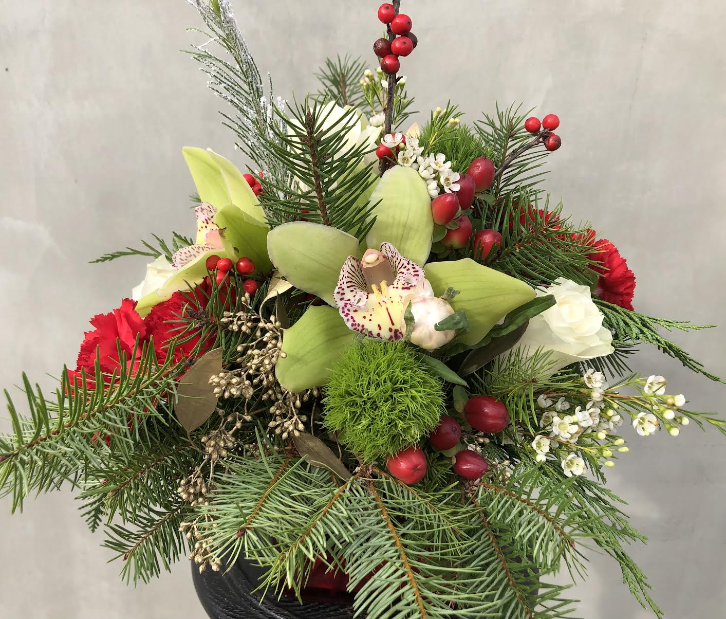 Cymbidium and Berries - Perfect for a holiday gift! Includes cymbidium, roses, carnations, berries, and pines all hand-arranged in a glass vase.