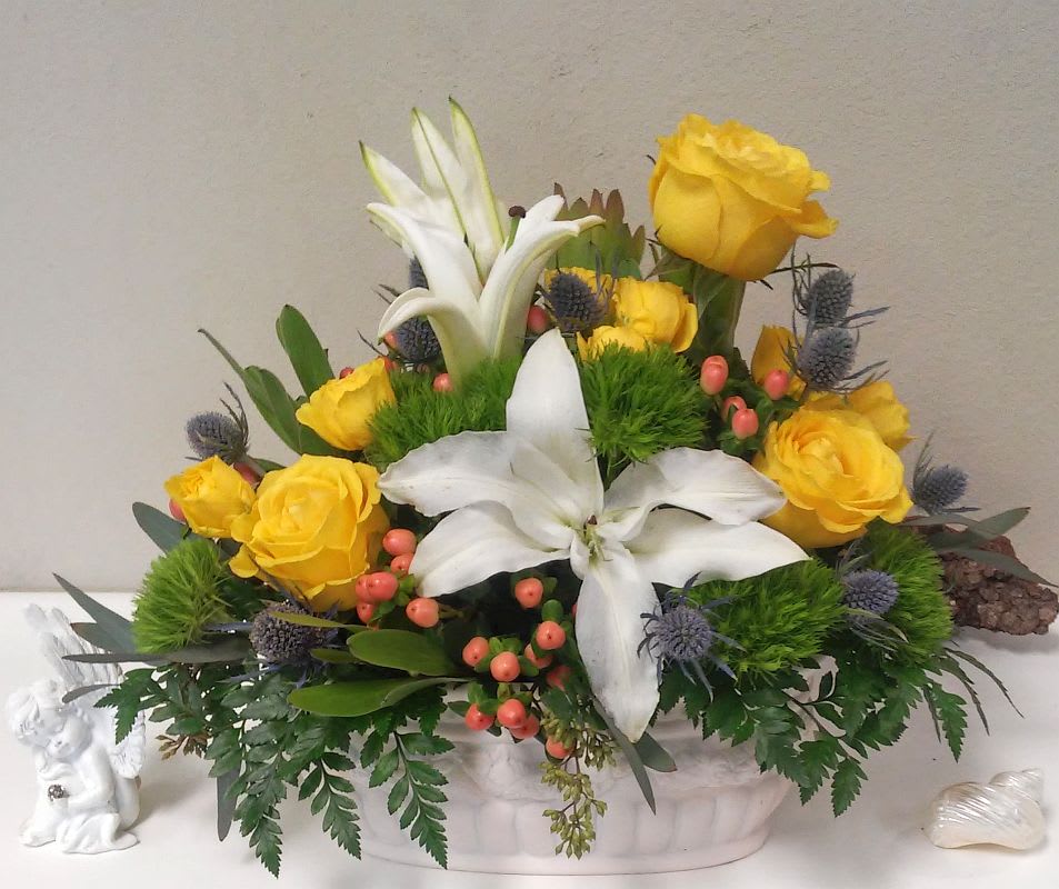 Amazing Grace - A simple arrangement of white lilies and colorful roses, mixed with an assortment of greenery and presented in a deco container, can be used to ornament any at-home or business event. An excellent all-purpose selection. The exact container may vary.