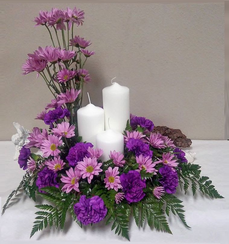 Lavender Memorial Tributes Lavender Memorial Tributes - Memorial offering made of with a candle trinity, lavender daisies and purple carnations.