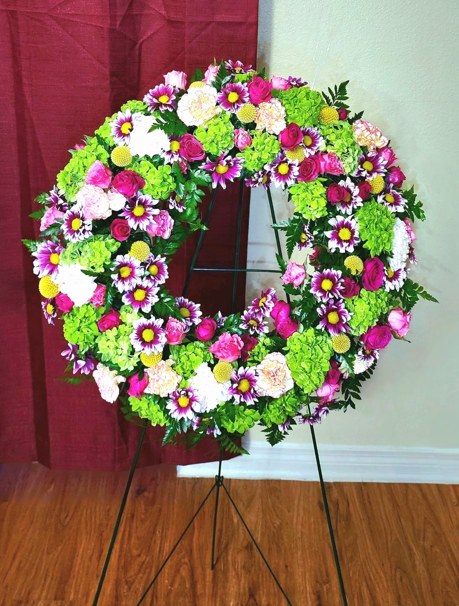 Cheerful Memories - Mini green hydrangeas, leather leaf, spray roses, pomms and hot pink carnations are the perfect mix to help during hard times.