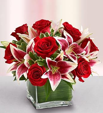 Modern Embrace Red Rose and Lily Cube - She''s always looking for the latest styles and hottest fashion trends. Send this truly original, contemporary bouquet of gorgeous red roses and elegant lilies, hand-arranged in a stylish glass cube vase, and she''ll think it''s the perfect accessory for her modern sensibility.