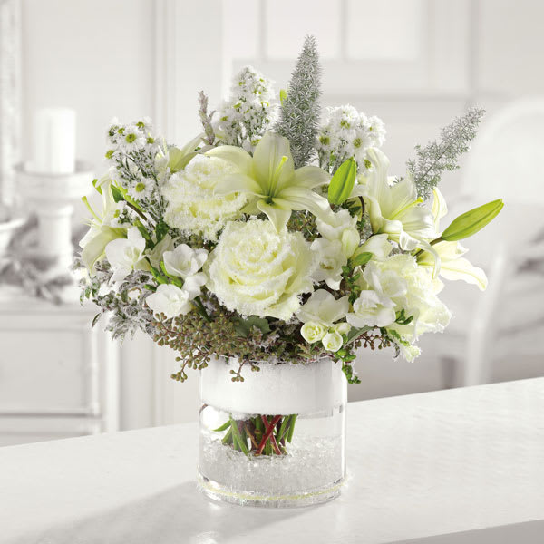 Silent Night - Snowy white roses, lilies, freesia and mixed greens come together in a glass cylinder vase to bring a sense calm amid the holiday hustle and bustle.