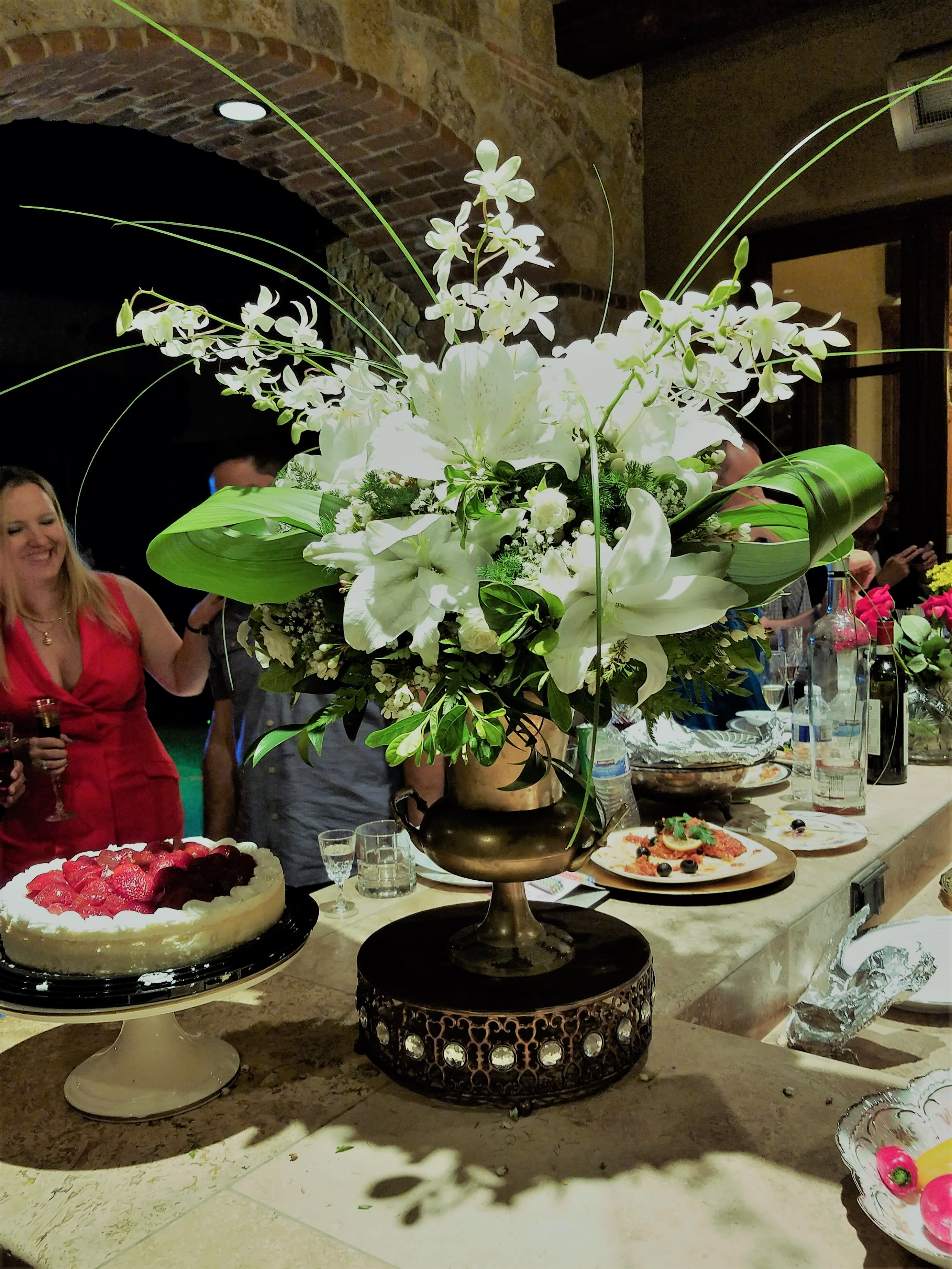 The Center of Attention - This arrangement is an eye catcher for your party. Created all in white and green classic combination with a twist of volume and dimension.    In some instances, our photo may represent an overall theme or look and include a one-of-a-kind vase which cannot be exactly replicated.  Although the actual bouquet may not precisely match the photo, its temperament will. Occasionally, substitutions of flowers and/or containers happen due to weather, seasonality and market conditions which may affect availability. If this is the case with the gift you’ve selected, we will ensure that the style, theme and color scheme of your arrangement is preserved and will only substitute items of equal value or higher value.  DELIVERY TIMES ARE USUALLY BETWEEN 2:30 PM THROUGH 6:30PM ON THE DAY OF DELIVERY. FOR SAME DAY ORDERS, PLEASE GIVE US AT LEAST 6 HOURS TO PROCESS AND DELIVER THE FLOWERS AS PRIOR ORDERS WILL BE PRIORITIZED. MORNING DELIVERY REQUESTS AND SPECIFIC TIME REQUESTS WILL BE AN ADDITIONAL $15 FOR A CONVENIENCE FEE CHARGE. OTHERWISE, SPECIFIC TIMES ARE ACKNOWLEDGED AND WE WILL DO OUR BEST TO ACCOMMODATE, HOWEVER WE CANNOT GUARANTEE ON TIME DELIVERY. GATE CODES ARE MANDATORY FOR OUR DELIVERY DRIVERS TO BE ABLE TO ENTER RESIDENTIAL OR COMMERCIAL BUILDINGS. IF YOU DON’T KNOW THE GATE CODE FOR A DELIVERY, PLEASE CONTACT THE RECIPIENT AND PROVIDE US WITH IT OR OUR DRIVER CAN CONTACT THE RECIPIENT BEFORE BEGINNING A DELIVERY ROUTE TO OBTAIN THE CODE. OUR POLICY STATES THAT DRIVERS WILL ONLY WAIT FIVE MINUTES OUTSIDE THE GATE FOR A CALLBACK. IF A DRIVER HAS TO LEAVE A PROPERTY, THE DELIVERY IS REASSIGNED FOR THE NEXT DAY AND MAY CHARGE AN ADDITIONAL DELIVERY FEE. THANK YOU FOR YOUR BUSINESS.