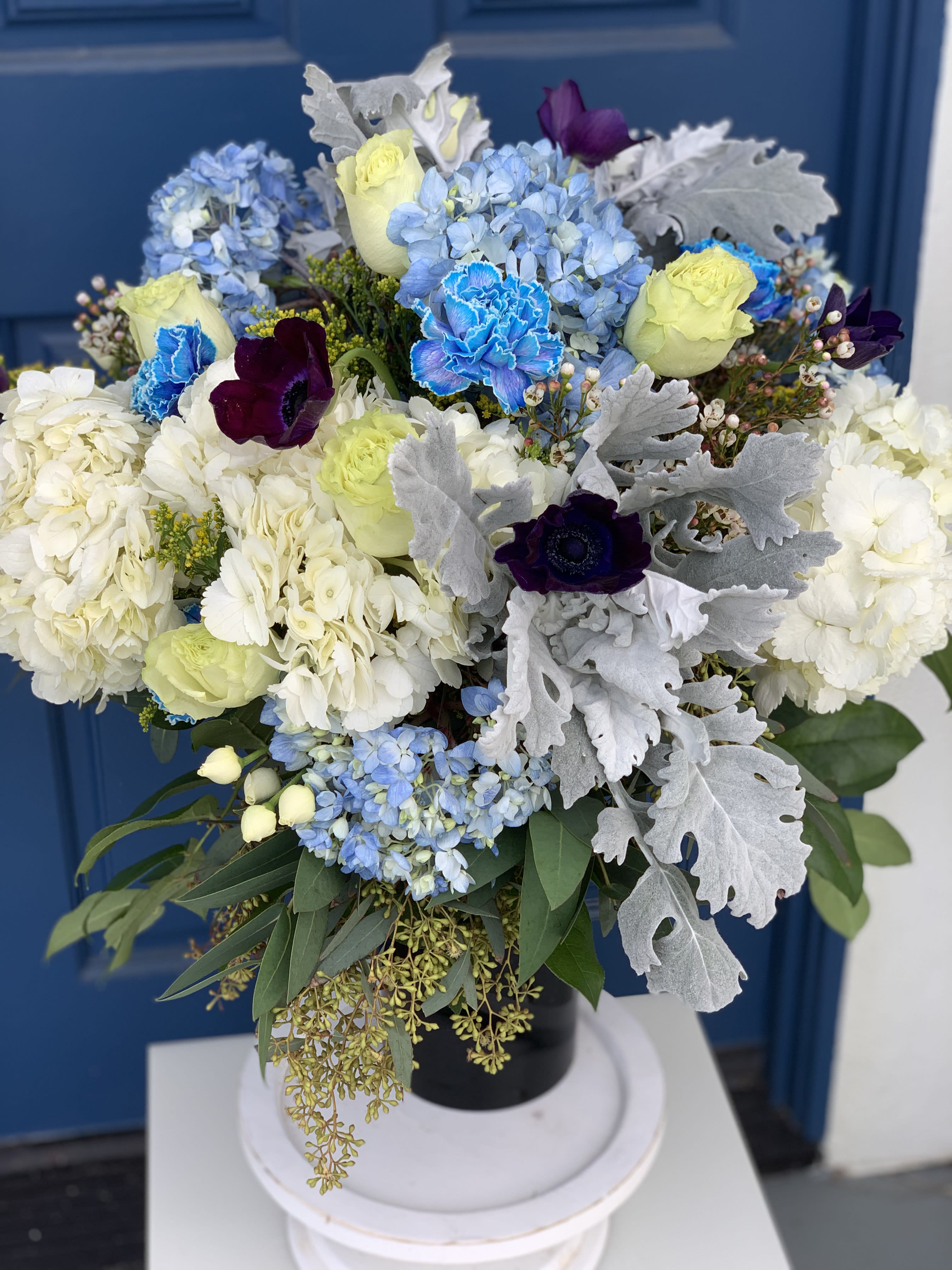 Snow Flakes - This arrangement is very attractive because of color combinations and volume and textures of the flowers combined in a glass vase. It will be a eye appealing statement for lovers of blue and purple tones. DELIVERY TIMES ARE USUALLY BETWEEN 2:30 PM THROUGH 6:30PM ON THE DAY OF DELIVERY. FOR SAME DAY ORDERS, PLEASE GIVE US AT LEAST 6 HOURS TO PROCESS AND DELIVER THE FLOWERS AS PRIOR ORDERS WILL BE PRIORITIZED. MORNING DELIVERY REQUESTS AND SPECIFIC TIME REQUESTS WILL BE AN ADDITIONAL $15 FOR A CONVENIENCE FEE CHARGE. OTHERWISE, SPECIFIC TIMES ARE ACKNOWLEDGED AND WE WILL DO OUR BEST TO ACCOMMODATE, HOWEVER WE CANNOT GUARANTEE ON TIME DELIVERY. GATE CODES ARE MANDATORY FOR OUR DELIVERY DRIVERS TO BE ABLE TO ENTER RESIDENTIAL OR COMMERCIAL BUILDINGS. IF YOU DON’T KNOW THE GATE CODE FOR A DELIVERY, PLEASE CONTACT THE RECIPIENT AND PROVIDE US WITH IT OR OUR DRIVER CAN CONTACT THE RECIPIENT BEFORE BEGINNING A DELIVERY ROUTE TO OBTAIN THE CODE. OUR POLICY STATES THAT DRIVERS WILL ONLY WAIT FIVE MINUTES OUTSIDE THE GATE FOR A CALLBACK. IF A DRIVER HAS TO LEAVE A PROPERTY, THE DELIVERY IS REASSIGNED FOR THE NEXT DAY AND MAY CHARGE AN ADDITIONAL DELIVERY FEE. THANK YOU FOR YOUR BUSINESS!