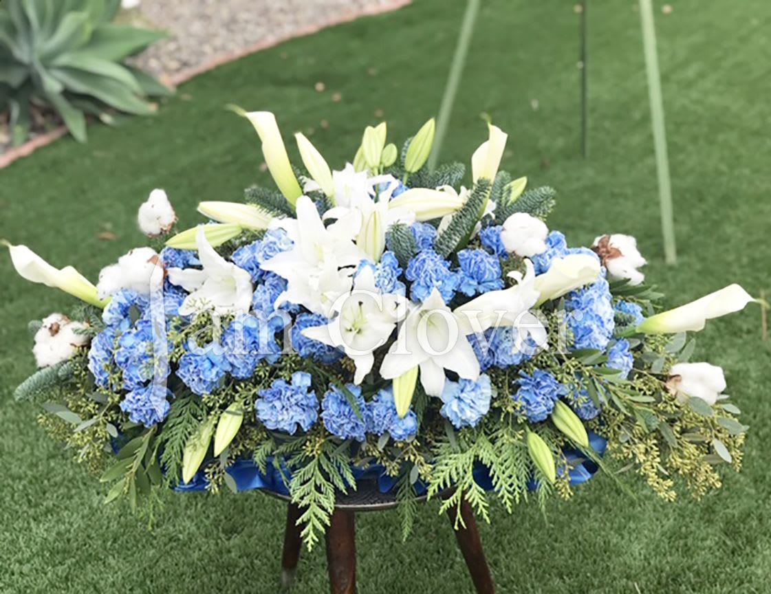 Blue Star Casket Spray - The arrangement is designed to reflect a sense of peace and the idea of a loved one shining brightly like a star in the sky, whose light continues to guide and inspire those left behind.  Fulfill your floral needs at I Am Clover in Ramona, CA, and experience the difference in quality, freshness, and care that comes with ordering locally.   Disclosure: Occasional substitutions of flowers happen due to weather, seasonality and market conditions. We will ensure that the style, theme and color scheme of your arrangement is preserved and will only substitute items of equal value or higher value.  Delivery: 2:30pm - 6:30pm Same Day Orders may take at least 6 hours to process and deliver Morning and Specific Delivery Time Requests:  will be charged a $15 convenience fee. Specific delivery times are acknowledged and we will do our best to accommodate, however we cannot guarantee on time delivery due to unforeseen events.  Gate Codes are mandatory for our delivery drivers to enter residential or commercial buildings. If you don’t know the gate code for a delivery, please contact the recipient and provide us with it or our driver can contact the recipient before beginning a delivery route to obtain the code. Our drivers will only wait five minutes outside the gate for a callback. If a driver has to leave a property, the delivery is reassigned for the next day and may charge an additional delivery fee.   Thank you! 