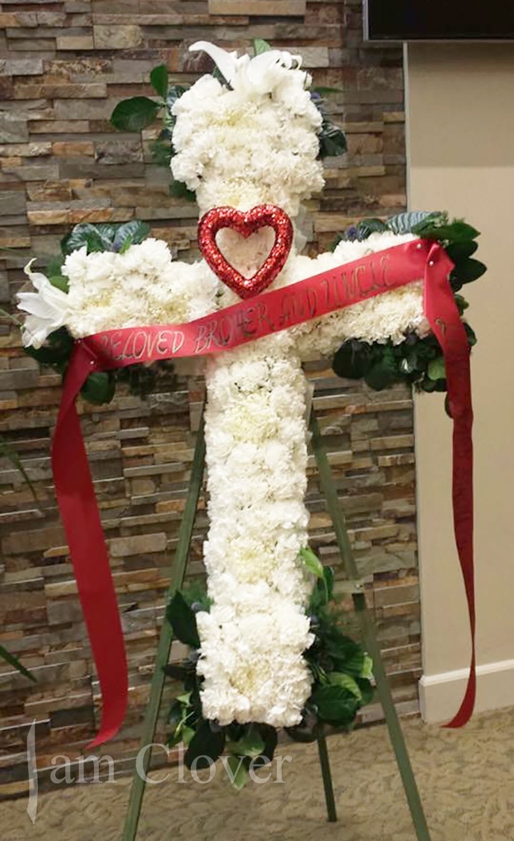 Funeral Cross - Funeral cross with white roses, lilies and carnations.   Comes in:  Small 20'', Medium 24'' (Deluxe), Large 30''(Premium).  Fulfill your floral needs at I Am Clover in Ramona, CA, and experience the difference in quality, freshness, and care that comes with ordering locally.   Disclosure: Occasional substitutions of flowers happen due to weather, seasonality and market conditions. We will ensure that the style, theme and color scheme of your arrangement is preserved and will only substitute items of equal value or higher value.  Delivery: 2:30pm - 6:30pm Same Day Orders may take at least 6 hours to process and deliver Morning and Specific Delivery Time Requests:  will be charged a $15 convenience fee. Specific delivery times are acknowledged and we will do our best to accommodate, however we cannot guarantee on time delivery due to unforeseen events.  Gate Codes are mandatory for our delivery drivers to enter residential or commercial buildings. If you don’t know the gate code for a delivery, please contact the recipient and provide us with it or our driver can contact the recipient before beginning a delivery route to obtain the code. Our drivers will only wait five minutes outside the gate for a callback. If a driver has to leave a property, the delivery is reassigned for the next day and may charge an additional delivery fee.   Thank you!