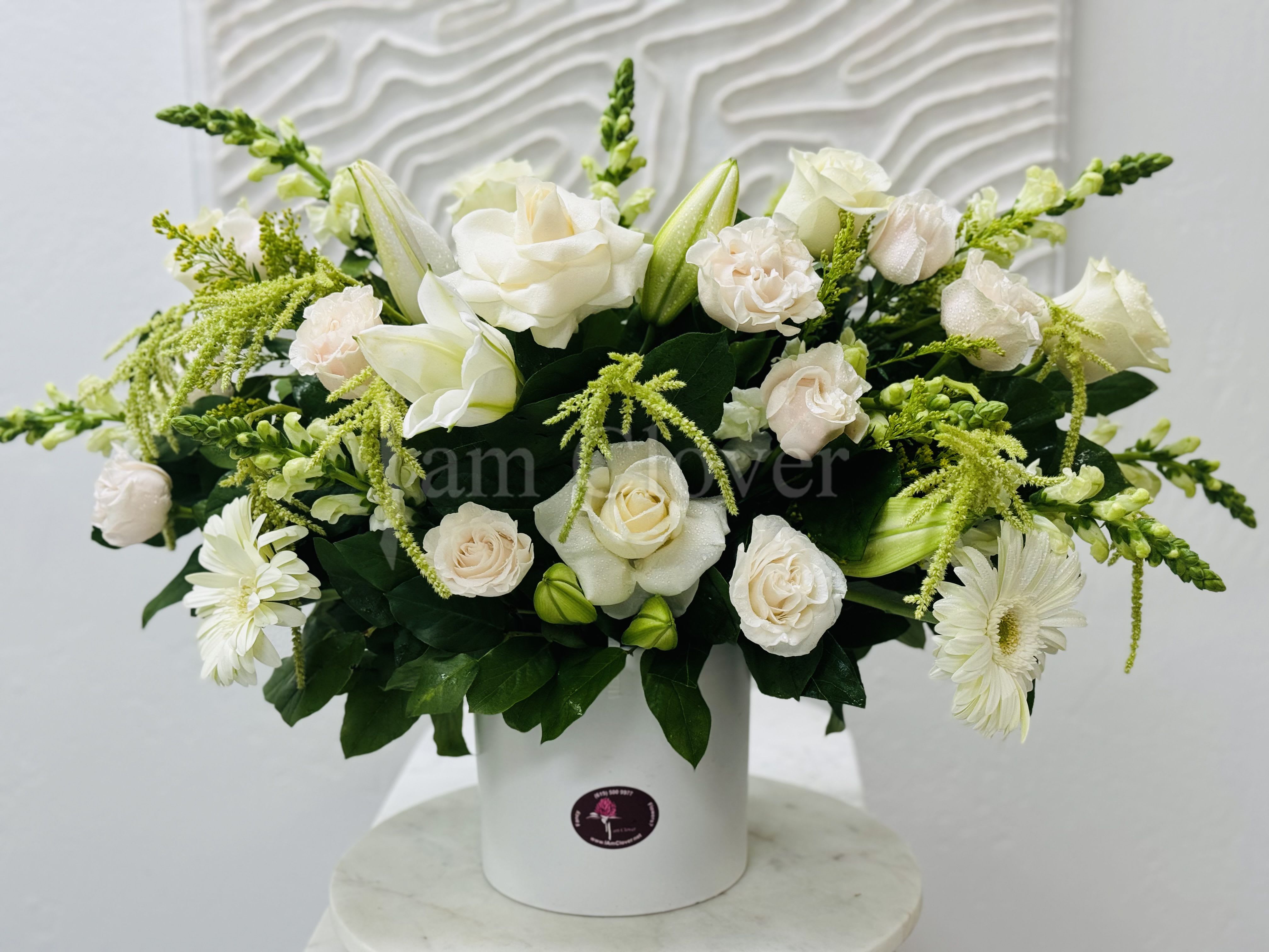 White Symphony  - A beautiful modern and elegant arrangement.   Fulfill your floral needs at I Am Clover in Ramona, CA, and experience the difference in quality, freshness, and care that comes with ordering locally.   Disclosure: In some instances, our photo may represent an overall look and include a one-of-a-kind vase which cannot be exactly replicated. Occasional substitutions of flowers and/or containers happen due to weather, seasonality and market conditions. We will ensure that the style, theme and color scheme of your arrangement is preserved and will only substitute items of equal value or higher value.  Delivery: 2:30pm - 6:30pm Same Day Orders may take at least 6 hours to process and deliver Morning and Specific Delivery Time Requests:  will be charged a $15 convenience fee. Specific delivery times are acknowledged and we will do our best to accommodate, however we cannot guarantee on time delivery due to unforeseen events.  Gate Codes are mandatory for our delivery drivers to enter residential or commercial buildings. If you don’t know the gate code for a delivery, please contact the recipient and provide us with it or our driver can contact the recipient before beginning a delivery route to obtain the code. Our policy states that drivers will only wait five minutes outside the gate for a callback. If a driver has to leave a property, the delivery is reassigned for the next day and may charge an additional delivery fee.   Thank you!