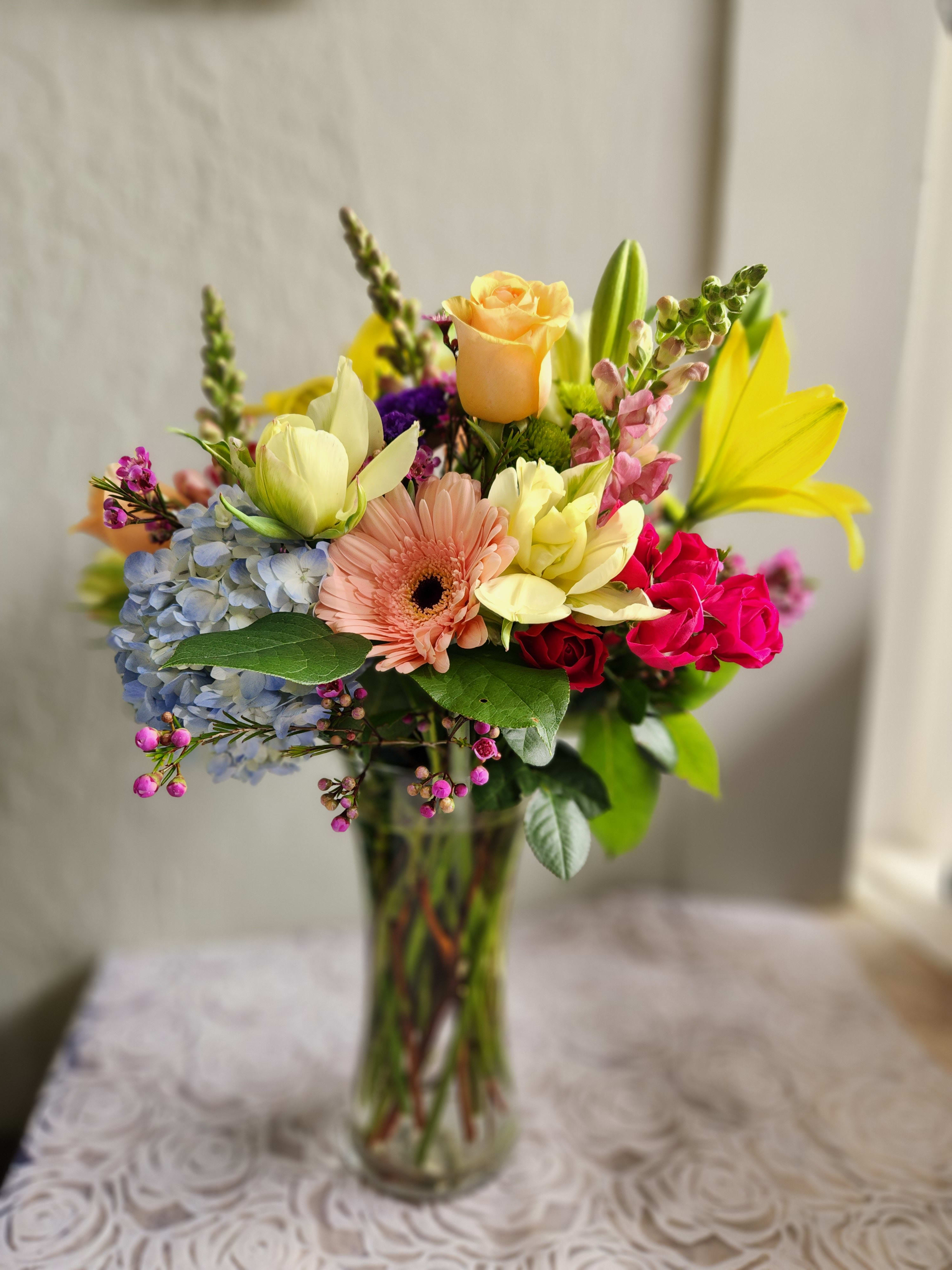 Jiovanna Arrangement  - A beautiful mix of in season blooms.  This arrangement is about 15&quot; tall in the vase This arrangement will bring a smile to anyone who receives it. 