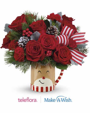 Send A Hug Reindeer Wish Bouquet Send A Hug Reindeer Wish Bouquet - Overflowing with festive blooms, this adorable reindeer delivers your holiday wishes! The glazed ceramic mug adds a whimsical touch to your seasonal sipping. This delightful bouquet showcases red roses, red carnations, miniature red carnations, dusty miller, douglas fir, and white pine.