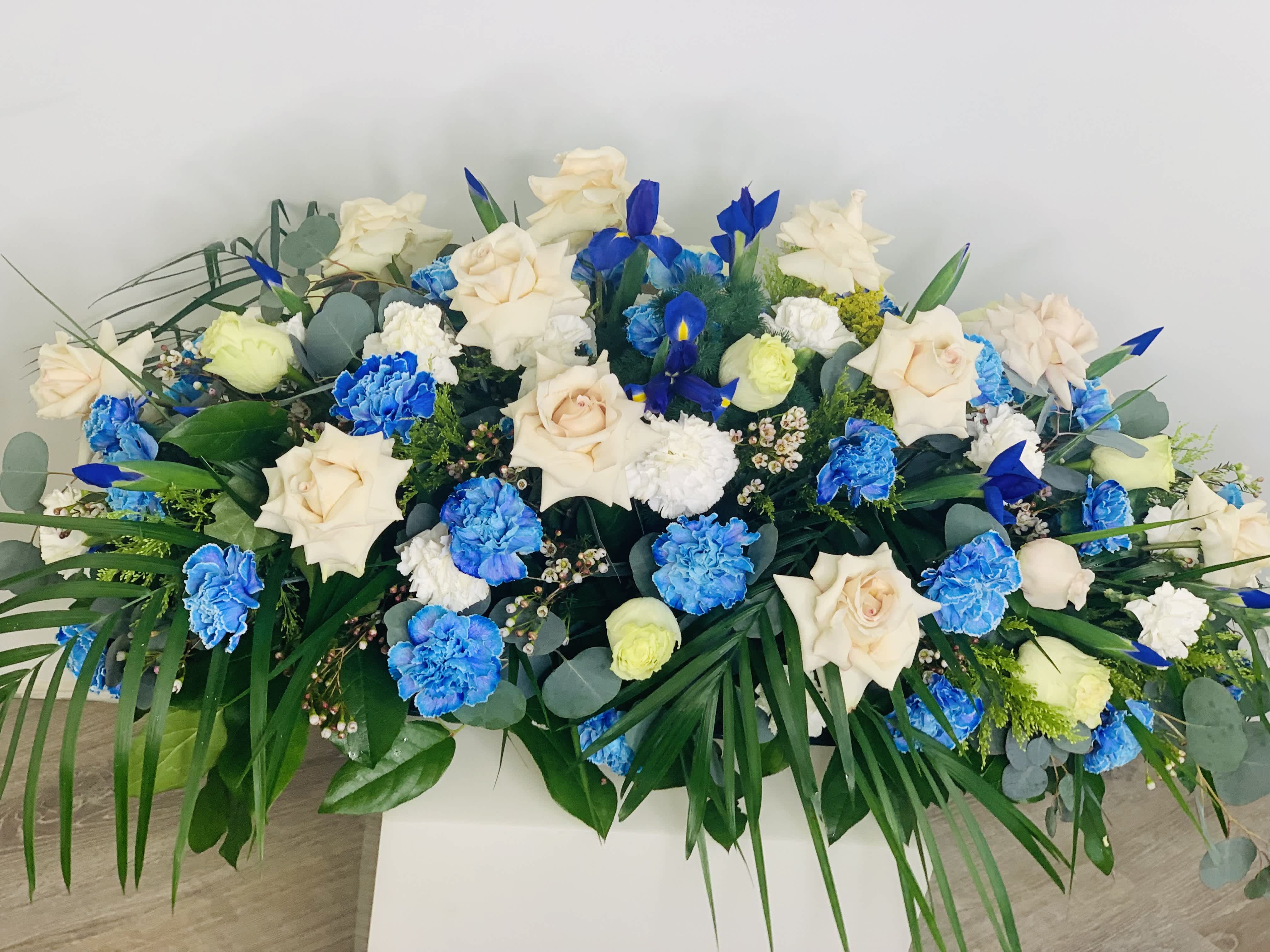 Casket Spray Blue Topaz - A beautiful casket spray with significant blue flowers that are unique and vibrant. Casket is full of freshest flowers.  Sizes Small, Medium, Large or Grand ($500).
