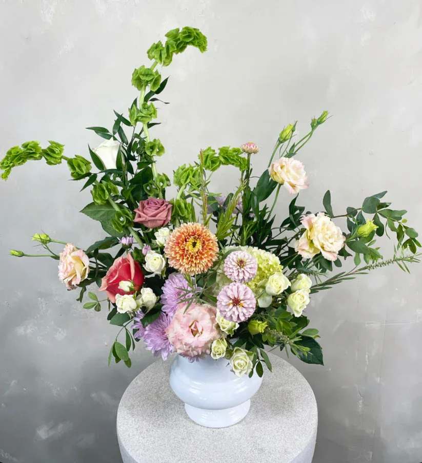 Sympathy Urn Sympathy Urn - This lush garden-style arrangement features a stunning mix of both local and imported blooms, thoughtfully curated for a sympathy gift. The color palette and flower varieties will vary weekly, but will always remain tasteful and fitting for the occasion. Urns are traditionally delivered to the funeral home for the services. The urn, measuring 7", may be either black or white, depending on availability.