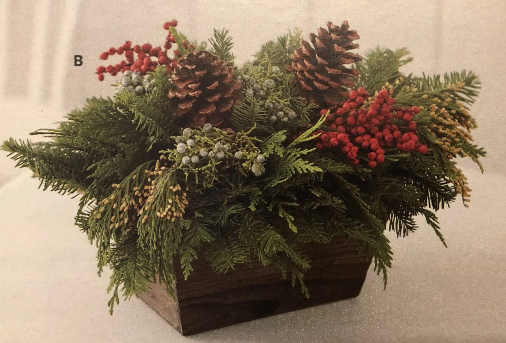 Rustic Greens - A variety of Holiday greens, pinecones, berries in a rustic container. 