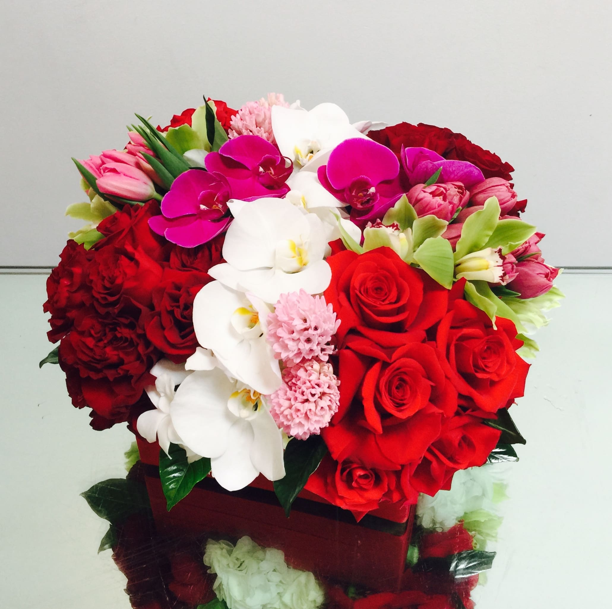 Ruby - A lovely red arrangement full of roses, hyacinth, tulips, cymbidium orchids, phalaenopsis orchids,  and hydrangea. It's a perfect lush gift to show your love.