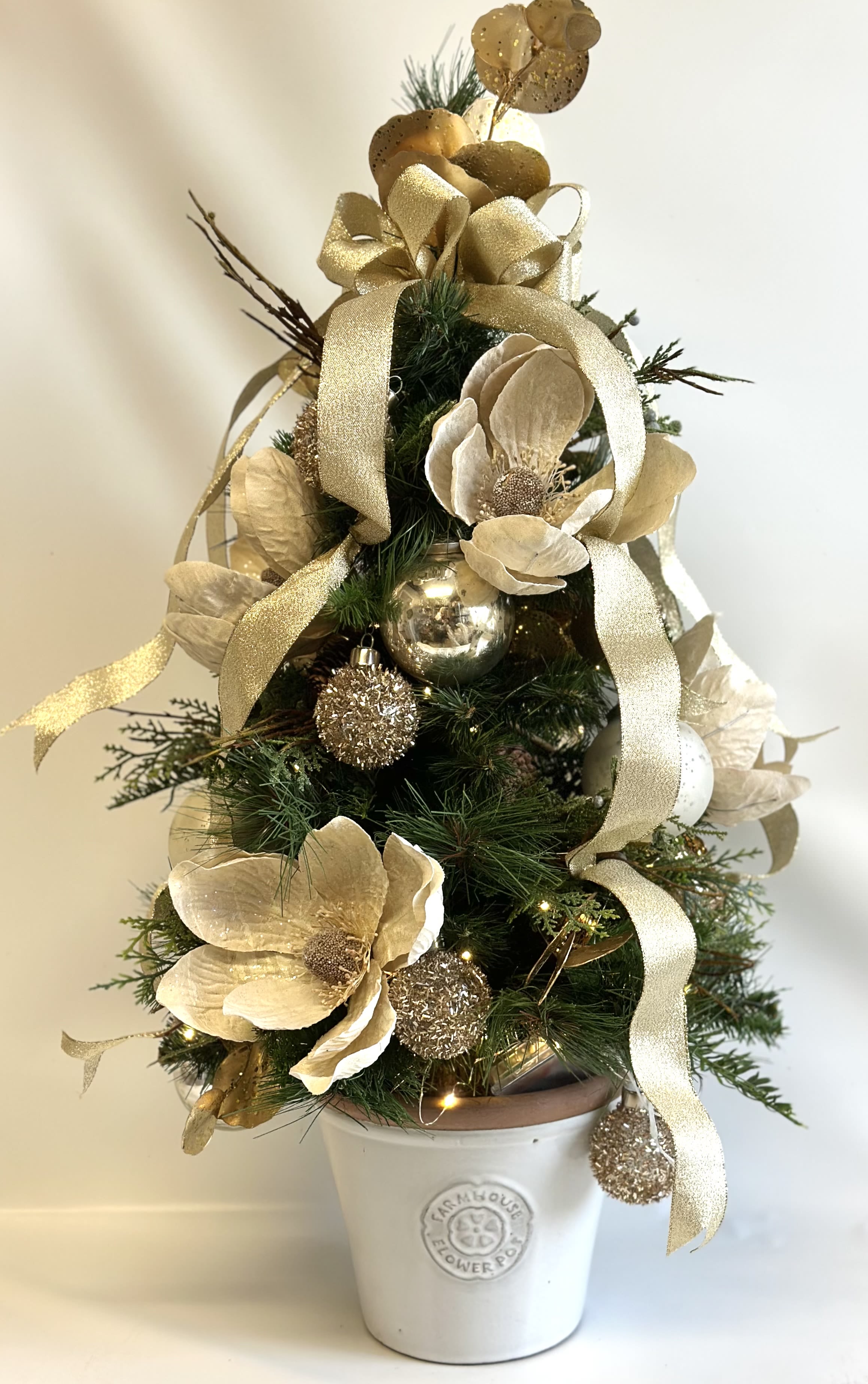 Christmas Magnolia Faux Tree Christmas Magnolia Faux Tree - This beautiful faux tree measures 2 1/2 ft tall. Done in gold, crème, rose gold and champagne. Perfect gift for that special someone.