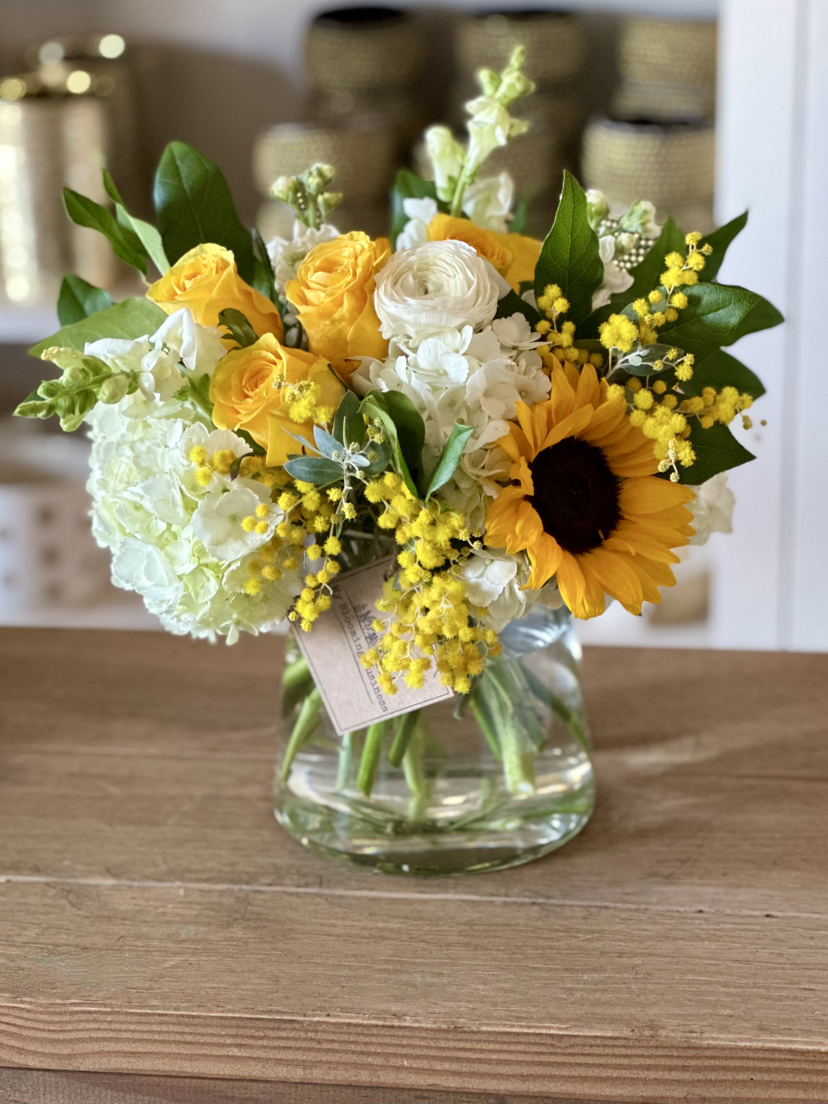 Hope and Fatih Hope and Fatih - Bring hope and faith to your home with this beautiful floral arrangement. This stunning display combines the perfect balance of warm yellow roses, delicately vibrant green hydrangeas, cheerful sunflowers, and lush snap dragons in a classical clear vase. Whether you're looking for a special way to say 'thank you', 'congratulations', or just want to bring a little bit of brightness into someone’s day, this thoughtfully put-together box is sure to bring smiles along with it! Show your family and friends the love and appreciation they deserve with this elegant gesture that guarantees lasting joy. So spread some sunshine with Hope and Faith today!