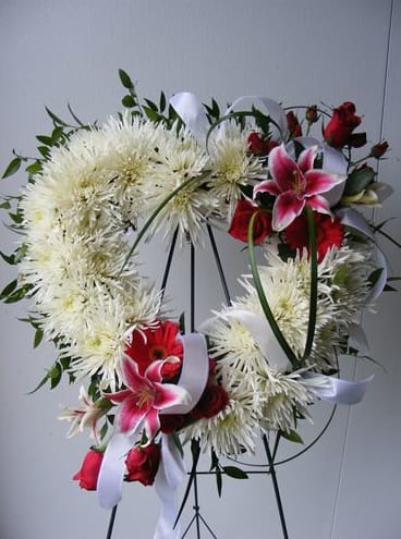 Standing Heart Wreath - Heart shaped wreath on standing easel.  Can be made in an array of colors and flowers. (As shown: fuji mums, stargazer lilies, gerber daisy and roses, or  purples/pinks all roses).