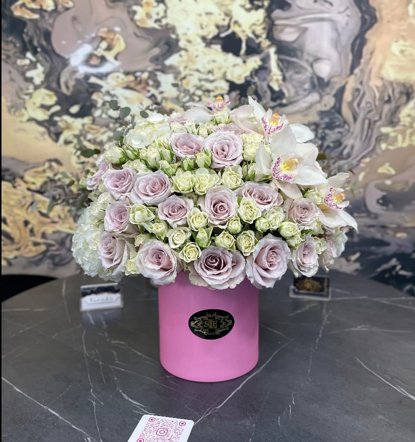 Blush and Bashful - Brighten any space with our Elegant Flower Box Arrangement! Bursting with vibrant blooms, this stunning display combines seasonal favorites with lush fillers.   Housed in a chic, reusable container, it makes a perfect centerpiece for any occasion be it a gift or a treat for yourself. Elevate your decor with this captivating arrangement that brings joy and sophistication to your home or office. Order yours today and let the beauty of flowers inspire you!