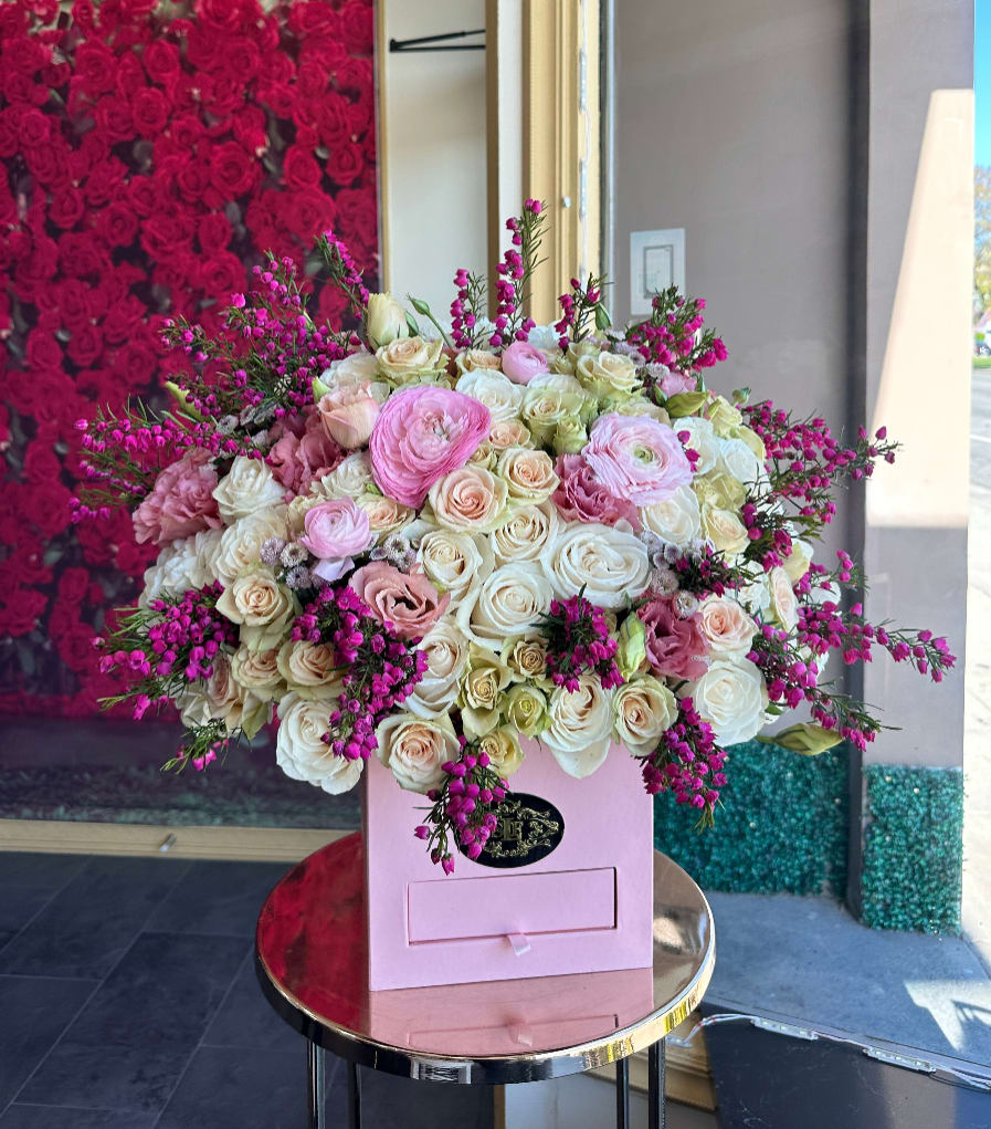 Blushing ruby Blushing ruby - Brighten any space with our Elegant Flower Box Arrangement! Bursting with vibrant blooms, this stunning display combines seasonal favorites with lush fillers. Housed in a chic, reusable container, it makes a perfect centerpiece for any occasion be it a gift or a treat for yourself. Elevate your decor with this captivating arrangement that brings joy and sophistication to your home or office. Order yours today and let the beauty of flowers inspire you!