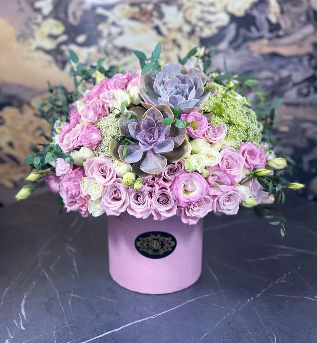 Blushing Beauty Blushing Beauty - Brighten any space with our Elegant Flower Box Arrangement! Bursting with vibrant blooms, this stunning display combines seasonal favorites with lush greenery. Housed in a chic, reusable container, it makes a perfect centerpiece for any occasion be it a gift or a treat for yourself. Elevate your decor with this captivating arrangement that brings joy and sophistication to your home or office. Order yours today and let the beauty of flowers inspire you!