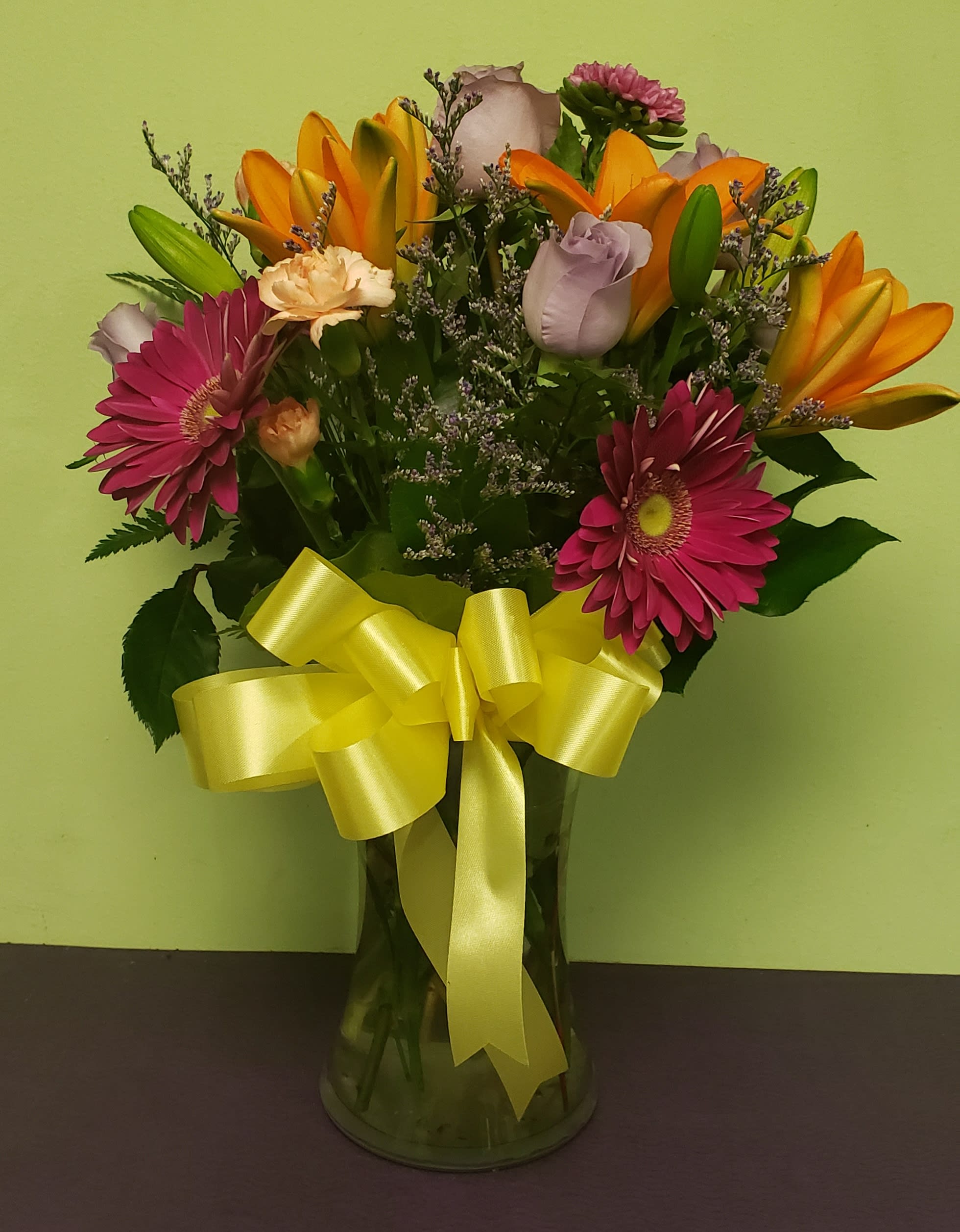 Vibrant Floral Spring Bouquet - Share this bright and vibrant floral creation with your friends and family. It is a great way to brighten any room, office or anyone's day! The arrangement includes Lilies, Daisies, Roses, Carnations and more! 