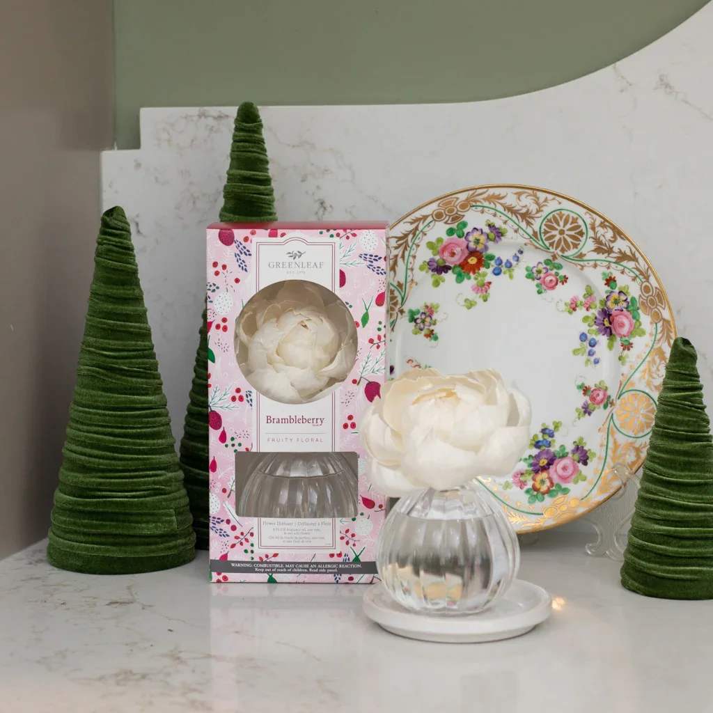 Brambleberry Flower Diffuser - Our Flower Diffuser includes your favorite Greenleaf fragrance oil and a sola paper flower that emits a beautiful, blooming scent for up to 60 days! As the fragrance oils are absorbed through the wick, the flower begins to “bloom,” slowly emitting the fragrance and eventually resembling real flower petals.   Did you Know? You can use a Refill! Bring your Flower Diffuser back to life by using one of our Reed Diffuser Oil Refills in the same fragrance to enjoy your Flower Diffuser one additional time after initial use.  What Makes it Special:  Beautiful fragrance created in-house by a team of professional perfumers Through Greenleaf Cares, proceeds of this product support organizations in the fight to end human trafficking  Fragrance: Brambleberry Fragrance Description: Sweet scents of raspberry, cassis, combined with rose and vanilla are spun together and softened with musk and amber for a berry festive fragrance.  Use and Care:  Place diffuser vase on a flat, stable surface Holding glass at base, carefully twist the cork out of the container Extend the stem of the flower fully and place it into the bottle, ensuring that the wire located within the wick is fully inserted into the neck of the container Enjoy the fragrance as well as the beauty of the flower as it blooms for up to 60 days When all the oil has been diffused and the flower begins to dry out, replace your Flower Diffuser  