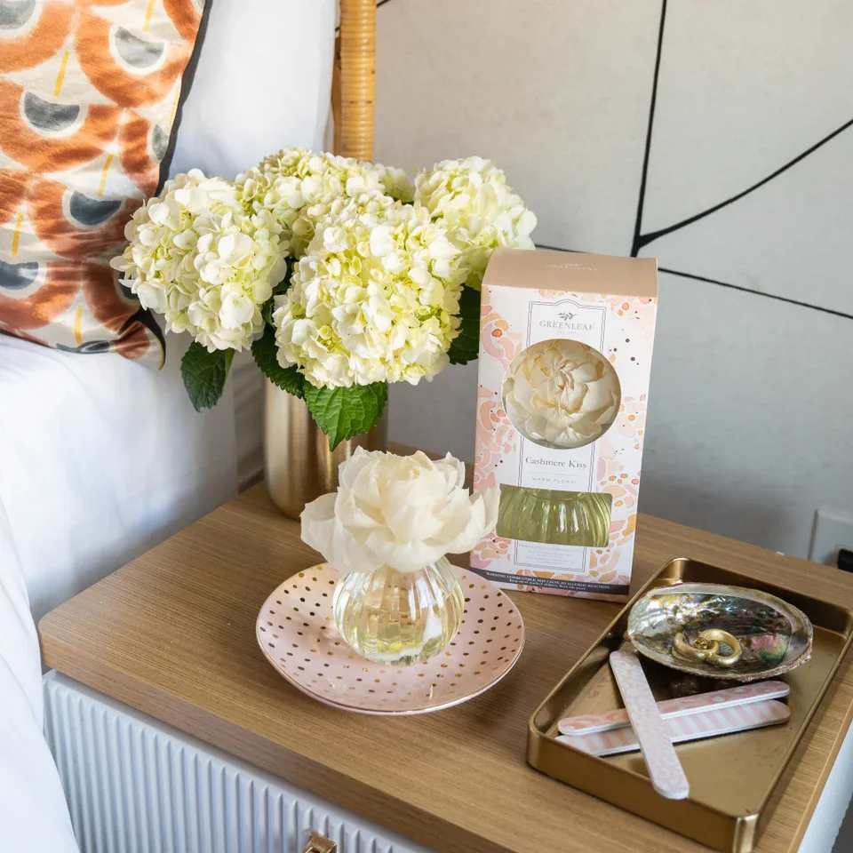 Cashmere Kiss Flower Diffuser - Our Flower Diffuser includes your favorite Greenleaf fragrance oil and a sola paper flower that emits a beautiful, blooming scent for up to 60 days! As the fragrance oils are absorbed through the wick, the flower begins to “bloom,” slowly emitting the fragrance and eventually resembling real flower petals. Did you Know? You can use a Refill! Bring your Flower Diffuser back to life by using one of our Reed Diffuser Oil Refills in the same fragrance to enjoy your Flower Diffuser one additional time after initial use.  What Makes it Special:  Beautiful fragrance created in-house by a team of professional perfumers Through Greenleaf Cares, proceeds of this product support organizations in the fight to end human trafficking  Fragrance: Cashmere Kiss Fragrance Family: Floral Fragrance Description: Cashmere Kiss is bound by passion and romance. Stirring citrus accords tenderly fold into fields of jasmine and rose.  Use and Care:  Place diffuser vase on a flat, stable surface Holding glass at base, carefully twist the cork out of the container Extend the stem of the flower fully and place it into the bottle, ensuring that the wire located within the wick is fully inserted into the neck of the container Enjoy the fragrance as well as the beauty of the flower as it blooms for up to 60 days When all the oil has been diffused and the flower begins to dry out, replace your Flower Diffuser 