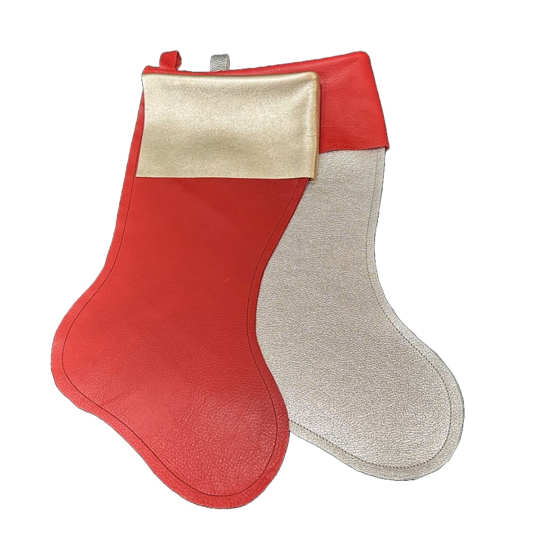 &quot;Chartreuse Luxe&quot; Leather Stocking - Introducing the &quot;Chartreuse Luxe&quot; leather stockings, a stunning creation by Chartreuse by Roje in collaboration with Jumping-Jax. These exclusive holiday decorations are crafted from premium leather, showcasing a vibrant red and shimmering gold design that exudes elegance and sophistication. Each stocking is **priced individually**, allowing you to select the perfect number for your holiday display.  The stockings feature a bold red leather body, contrasted beautifully with a luxurious gold cuff that adds a festive sparkle. The meticulous craftsmanship ensures each piece is not only visually striking but also durable, promising to be a cherished part of your holiday decor for years to come.  Perfectly sized to hold an abundance of gifts, the Chartreuse Luxe stockings are both functional and decorative. This limited-edition piece is available exclusively at Chartreuse by Roje's boutique, making it an ideal gift or a sophisticated addition to your own holiday celebrations. Embrace the modern elegance of these stockings and elevate your festive decor with their timeless charm.