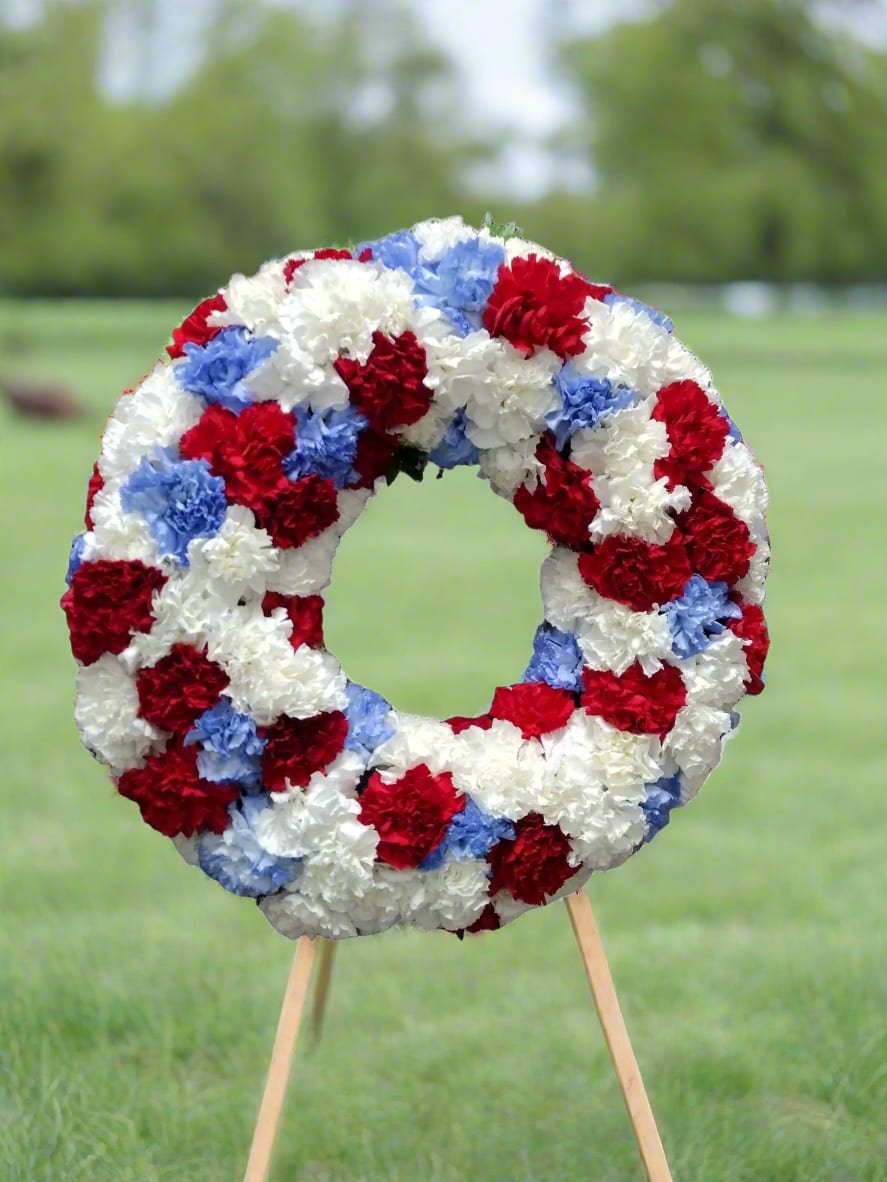 Honor &amp; Rememberance Memorial Wreath - Celebrate the lives of your loved ones with our exquisite red, white, and blue memorial wreaths. Crafted with care, these stunning arrangements are perfect for honoring special occasions and paying heartfelt tributes. Let the vibrant colors symbolize your love and remembrance, making every moment a cherished memory.  Each arrangement is custom-made to closely resemble your chosen design, ensuring a unique tribute tailored just for you. Please note that due to the natural variations in flowers, color substitutions may occur, and prices may vary based on seasonal availability. Don't forget to include your desired script in the notes section for a personal touch!