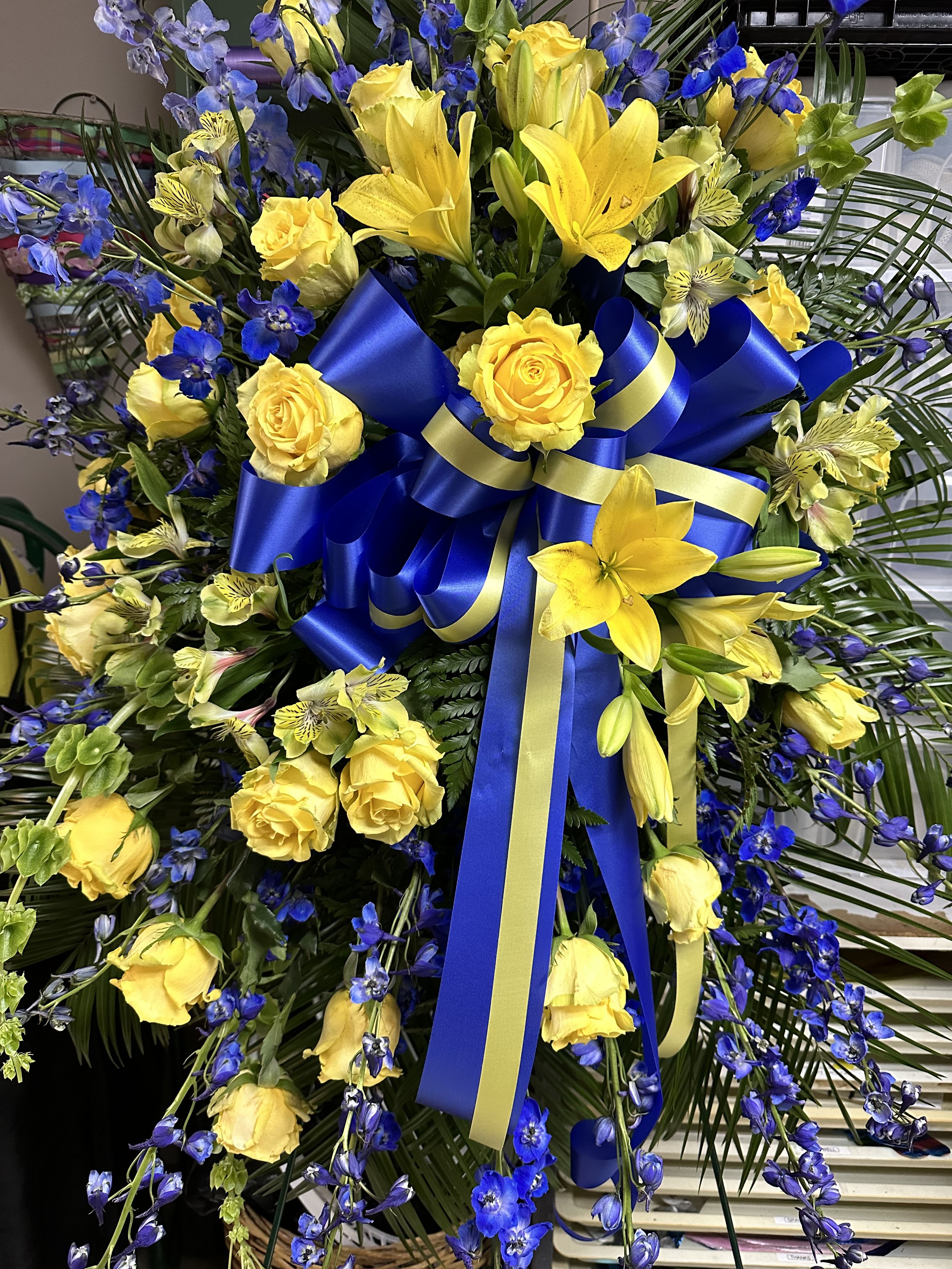 Yellow and Blue Standing Spray Yellow and Blue Standing Spray - Standing spray with yellow roses and lilies along with other yellow and blue flowers.