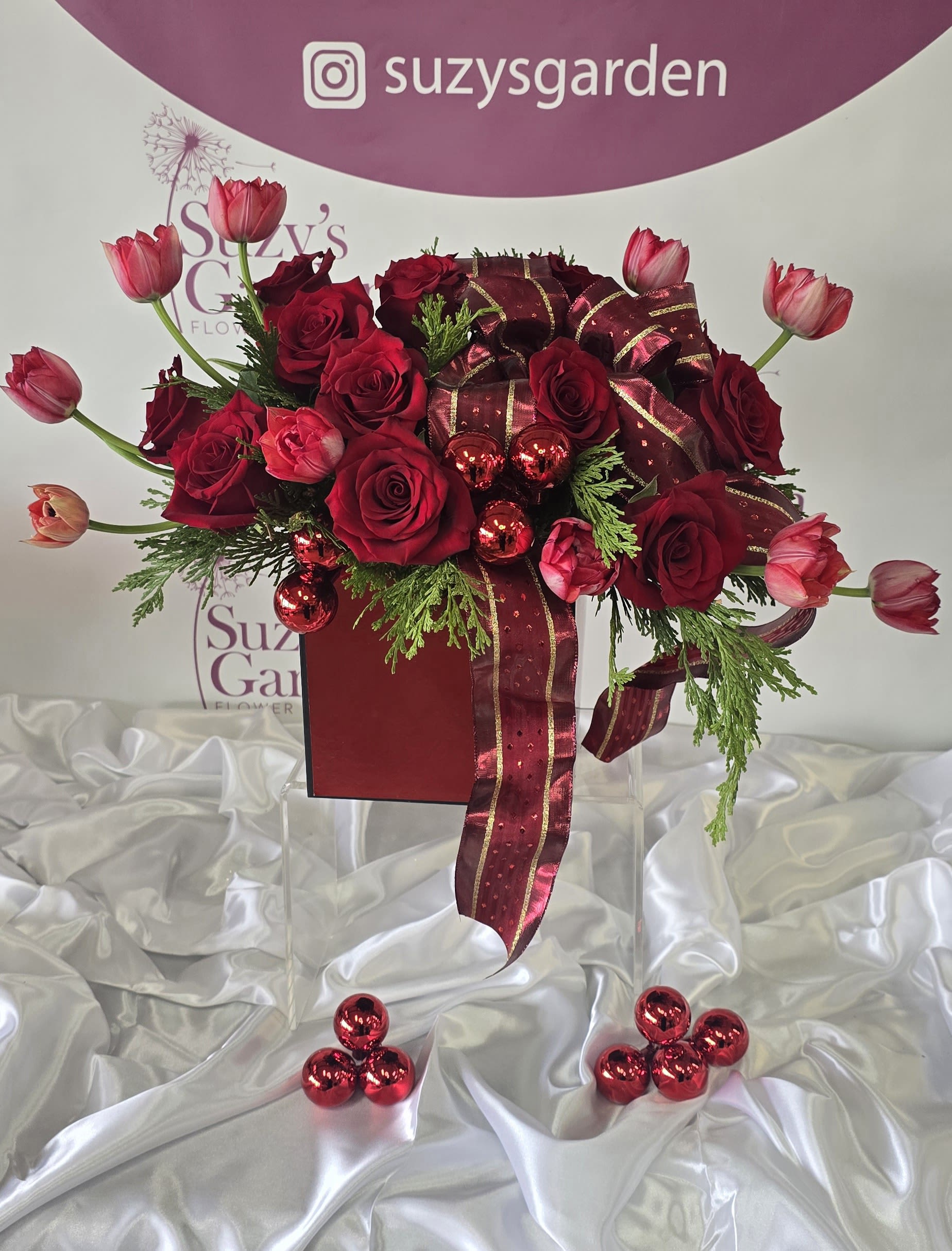Christmas Arrangement #1 - A festive Christmas flower arrangement featuring roses, surrounded by mixed flowers.
