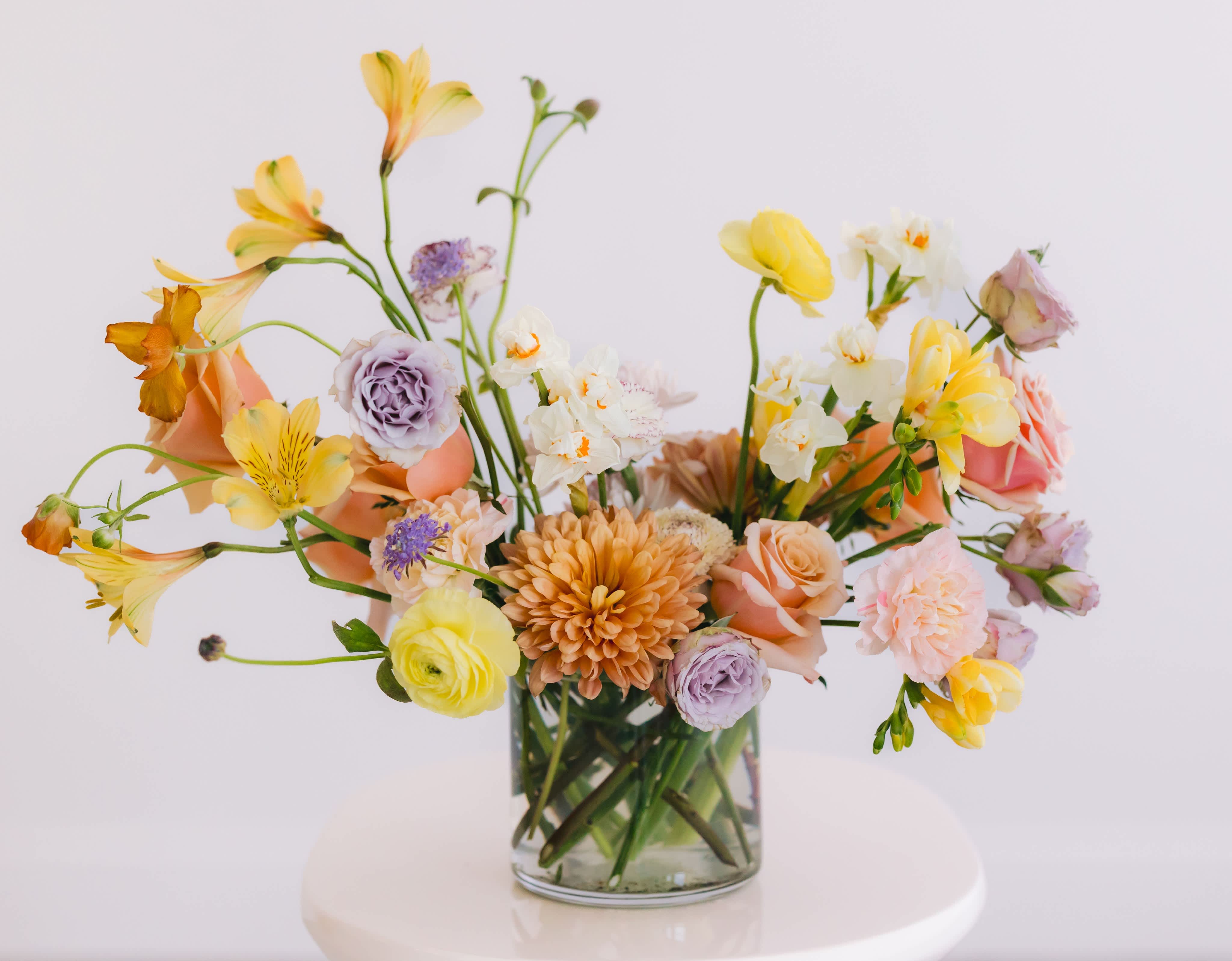 THE PARKER - This medium sized arrangement is created in a glass cylinder and is an all floral design using some seasonal textures that add color and very minimal &quot;green&quot; foliage.  Packaged in our signature white tissue and black logo ribbon.  **Please note that our selection of flowers and color palette changes from week to week and all substitutions will be of equal value. 