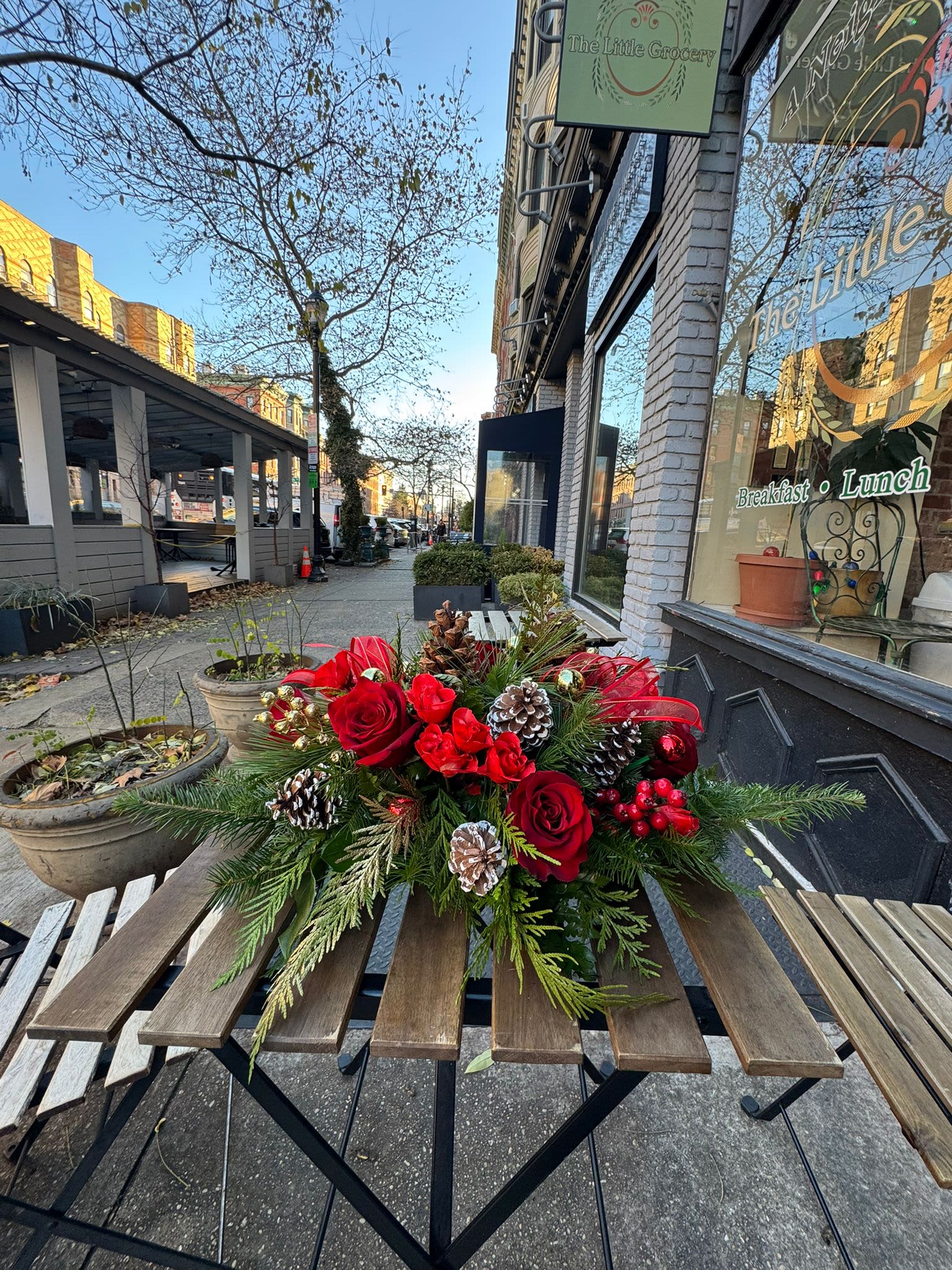 Christmas Eve Memories  - Relive the magic of Christmas Eve with this charming table arrangement. Christmas Eve Memories combines the warmth of deep red flowers with the freshness of winter greenery, evoking the nostalgia of family hugs and the glow of holiday lights. Gold details and candle accents create a cozy, elegant atmosphere, perfect for special dinners or unforgettable gatherings.