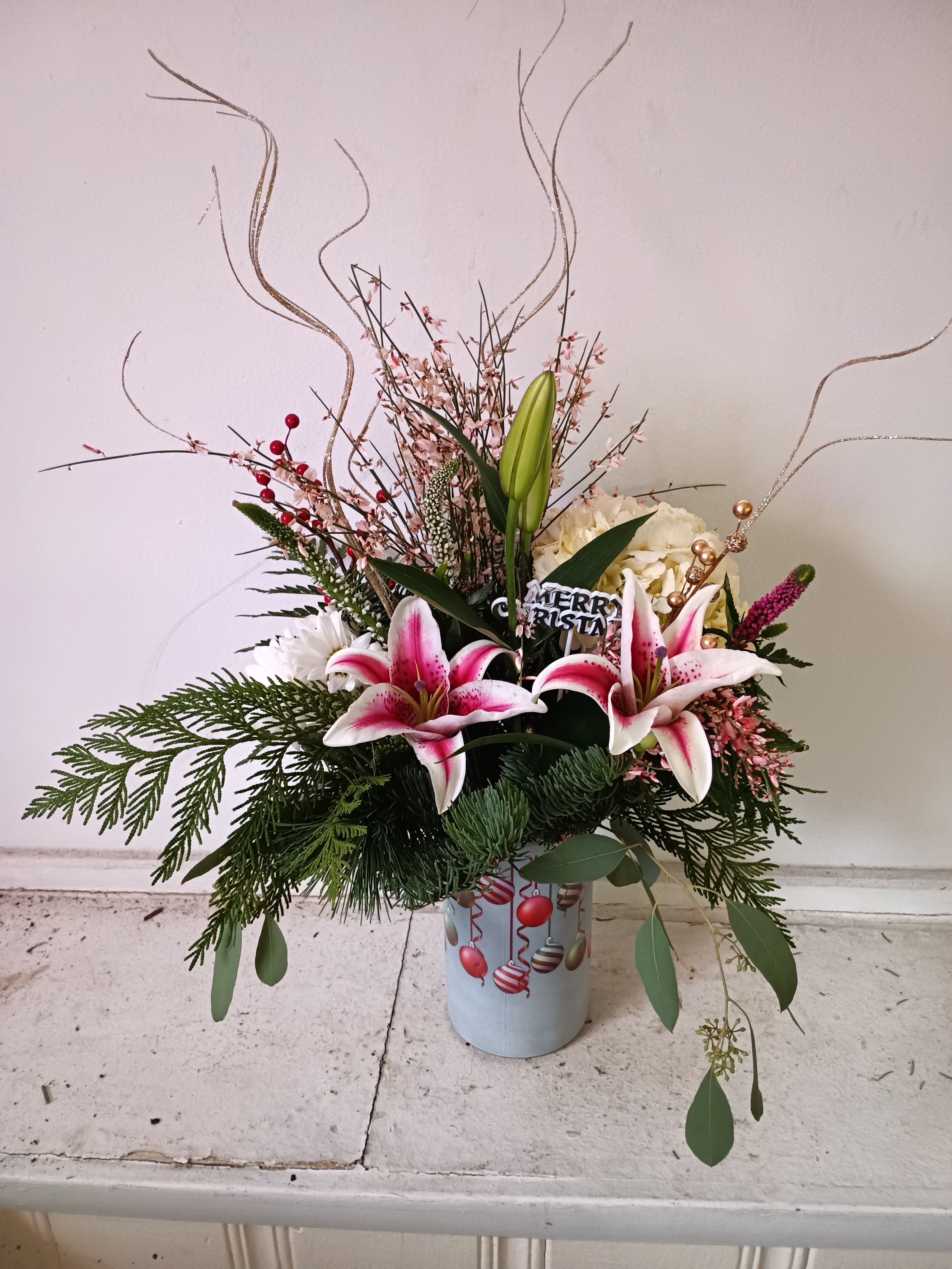 Happy Holiays! - Festive Christas ornaments vase with varied Christmas greens, stargazer Lily, white hydrangea, beautiful regrant ginestra and seasonal berries 