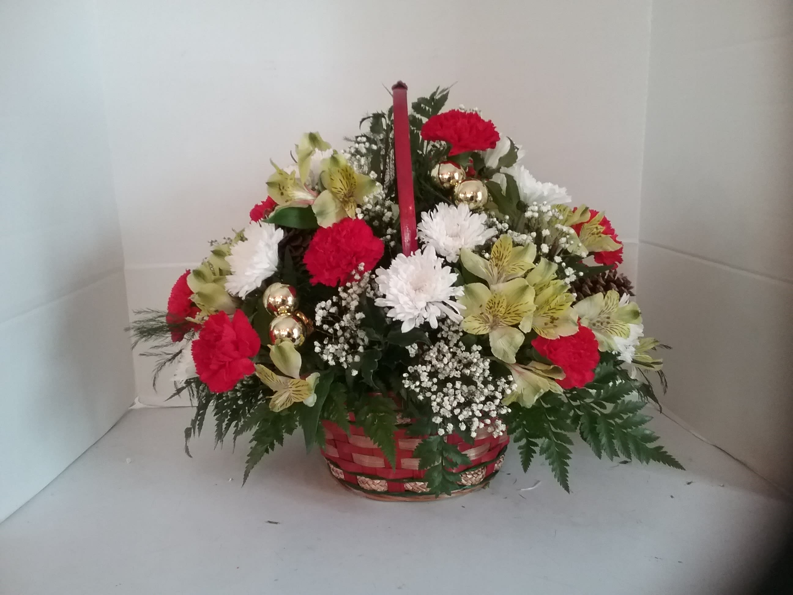 Basket of wishes Basket of wishes - Red, green and white flowers make this basket something everyone will love. Pine cones and shiny glass balls give just the right amount of shine for the holiday's.
