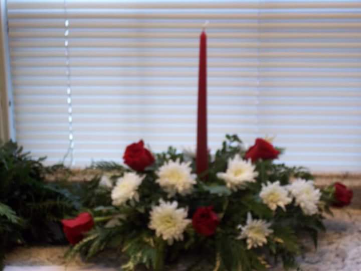 Christmas for one Christmas for one - Red roses and white cushion mums and greens make this a fitting centerpiece for a small table.
