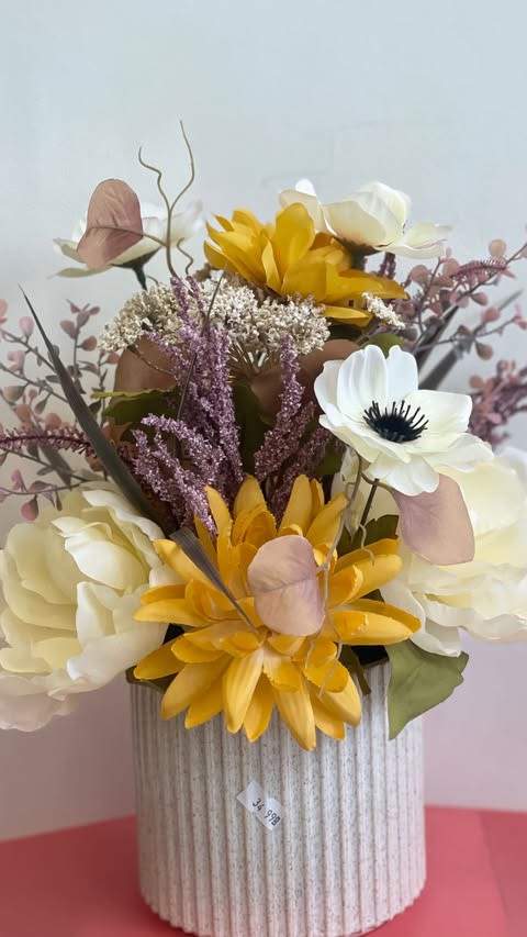 Elegant Floral  - This stunning floral arrangement features a mix of vibrant yellow, soft white, and blush pink artificial blooms, complemented by textured greenery. The flowers are displayed in a ribbed ceramic vase, adding a sophisticated touch to any room. Perfect for home decor or as a thoughtful gift for special occasions.