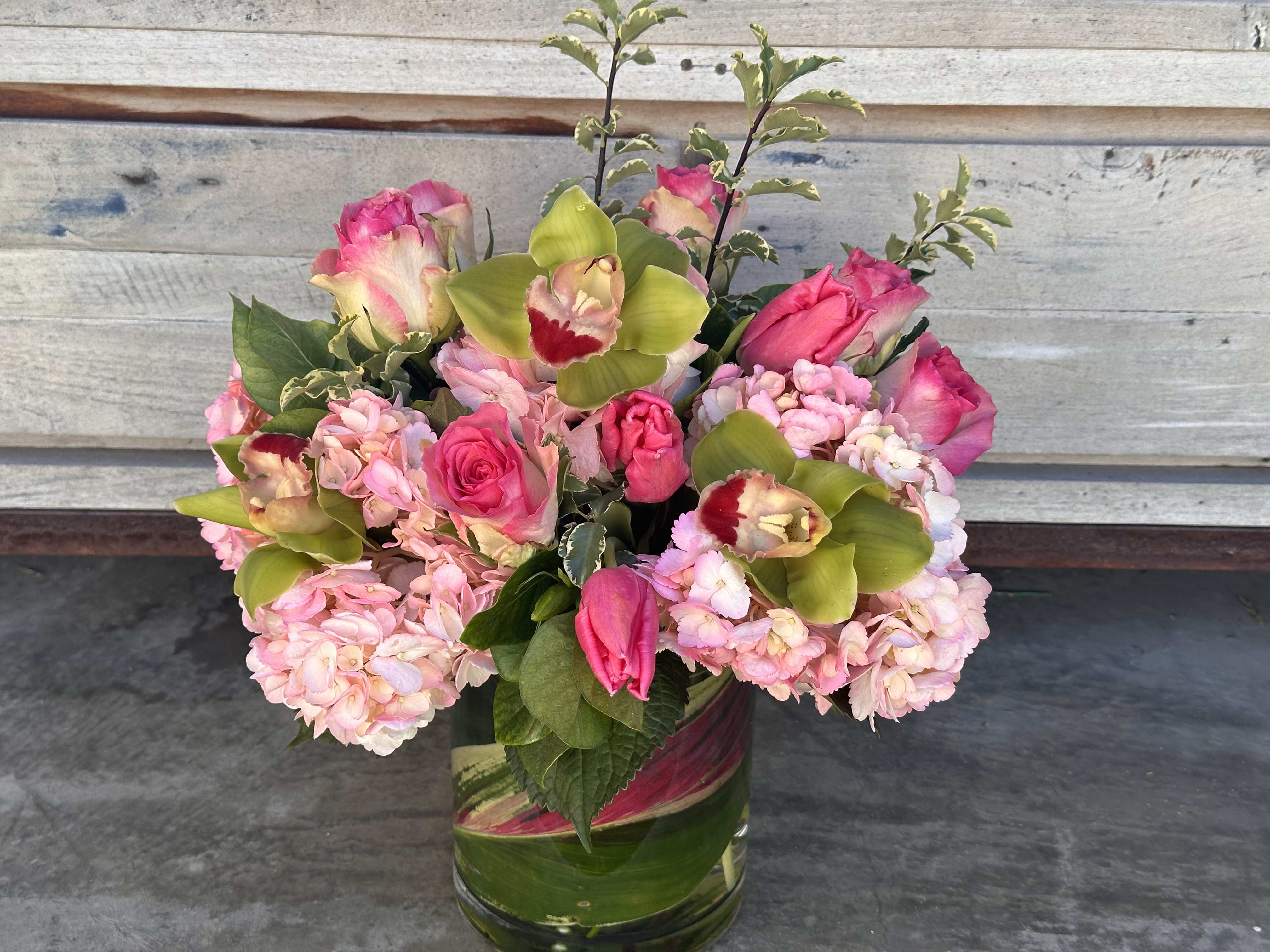 Sweethearts Delight Sweethearts Delight - Perfect gift for your sweetheart - 6" glass cylinder with luscious pink hydrangea, pink tulips, pink roses green cymbidum gardenia green & Italian pitasporum greens