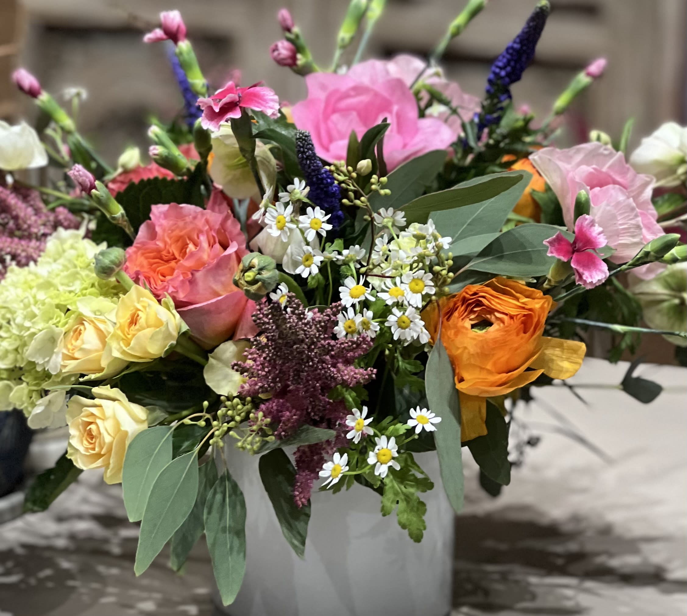 Promise of Spring - Oh Spring! These classic favorites remind us of warmer times and to celebrate the day at hand! Roses, ranunculus, feverfew, veronica, solomio, and hydrangea 