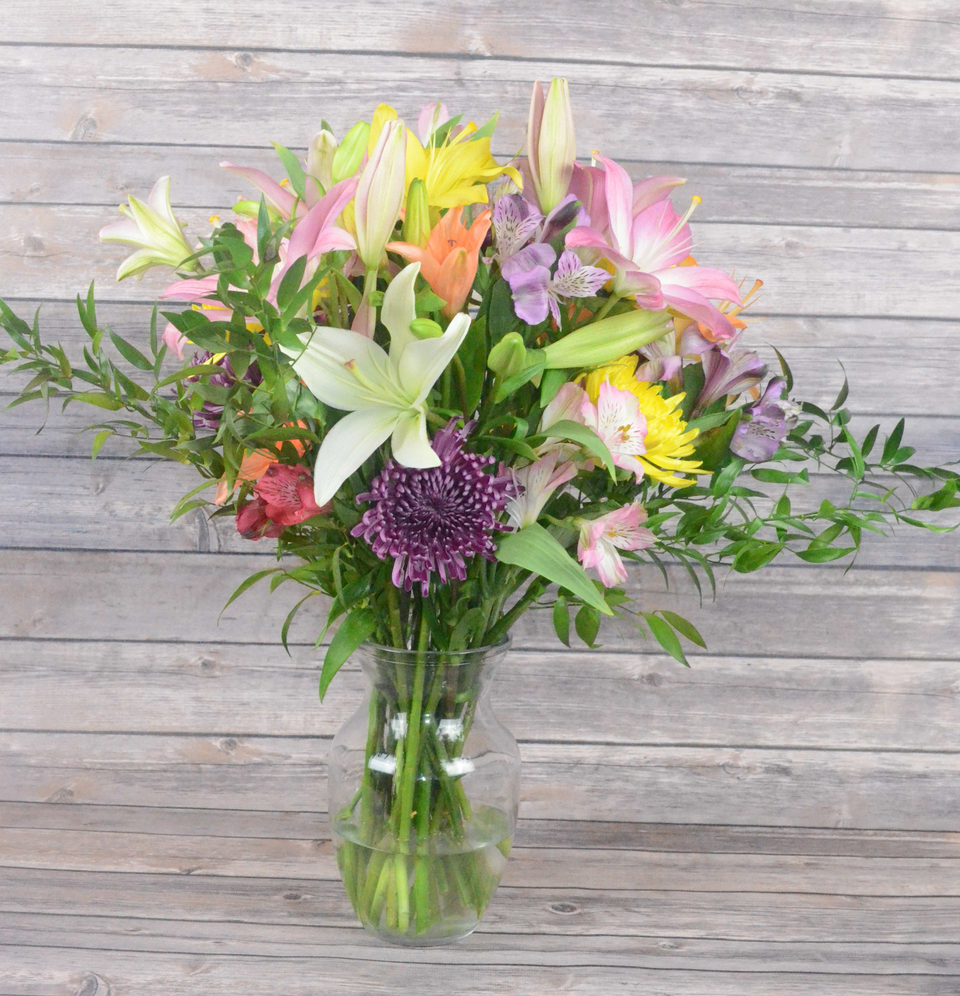 A Taste of Spring - Bring spring in no matter what the season with this thoughtful blend of lilies, chrysanthemums, and alstroemerias.  All bouquets are arranged by our professional floral design team accented with seasonal filler (i.e. greenery, baby’s breath, etc.) inside an elegant glass vase or gift box. When artistically designed in a clear glass vase arrangement measures approximately 23&quot;H x 18&quot;L. Blooms are hand delivered in person to enhance any celebration or a “just because” surprise. Deliveries are done between 10am - 5pm. If the recipient is not home we will leave the delivery if safe from the elements. We will call or text the recipient and let them know a delivery has been left.  
