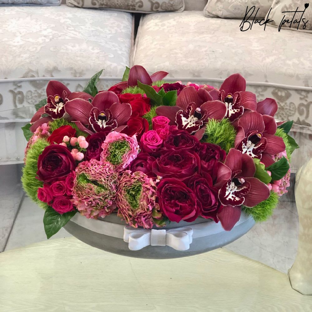Red Garden In A Ceramic Vase - This breathtaking red hued beauty will capture the attention of your specialяrecipient! Red roses are surrounded яby fuchsia spray roses, ranunculus, premiumяburgundy orchids, greenяdianthus, and greenяaccent leaves. Arrangement includes:  Fresh Black Petal Signature roses, orchids &amp; other flowers BP Ceramic Vase measured at approx. 40 CM ' x 20 cmя Care instructions Custom greeting card DISCLAIMER - FRESH FLOWERS: These are fresh cut flowers and are perishable. Please follow care &amp; instructions. Please note that if no variations from the list are chosen, you will receive the featured arrangement unless a substitution may need to be made based on the season, availability of flowers, or other unforeseen and uncontrollable circumstances occur. By making a purchase on this website, the customer authorizes substitutions within a specific color palette. Necessary substitutions to the arrangement will be at the designer?s discretion.