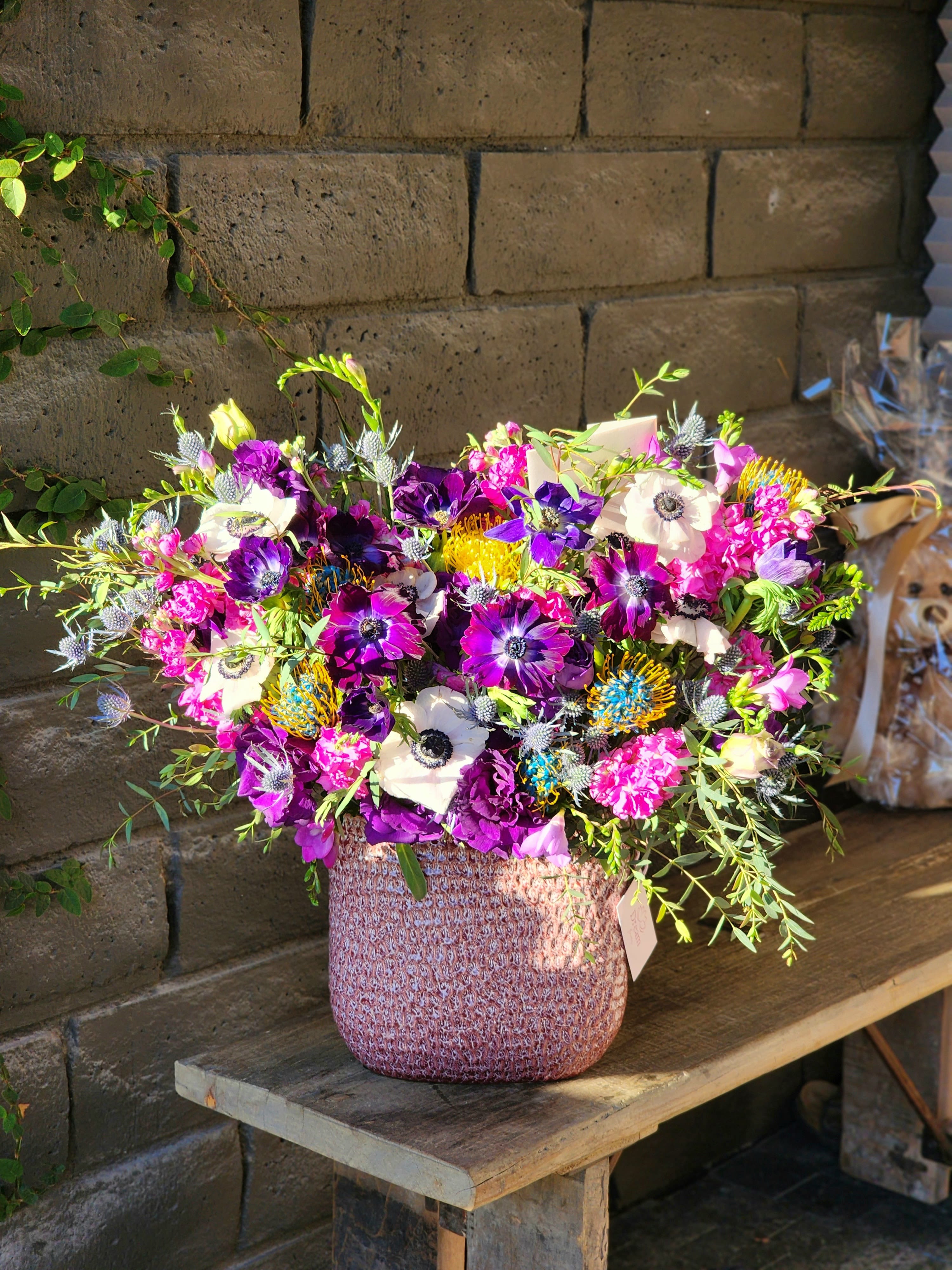 Purple Fantasy  - This stunning arrangement combines vibrant fresh greens with delicate white and purple anemones, creating a lively and modern composition. The interplay of unique flowers and textures makes this a luxurious choice for special occasions or as a statement decor piece. 