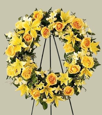 Sunshine Wreath - A standing wreath adorned with yellow flowers embodies warmth, hope, and friendship, making it a thoughtful choice for honoring a life lived with brightness and positivity. Its sunny hues convey a message of optimism and fond memories, providing solace and support to those grieving the loss of a loved one. Approximately 22-26 Inches