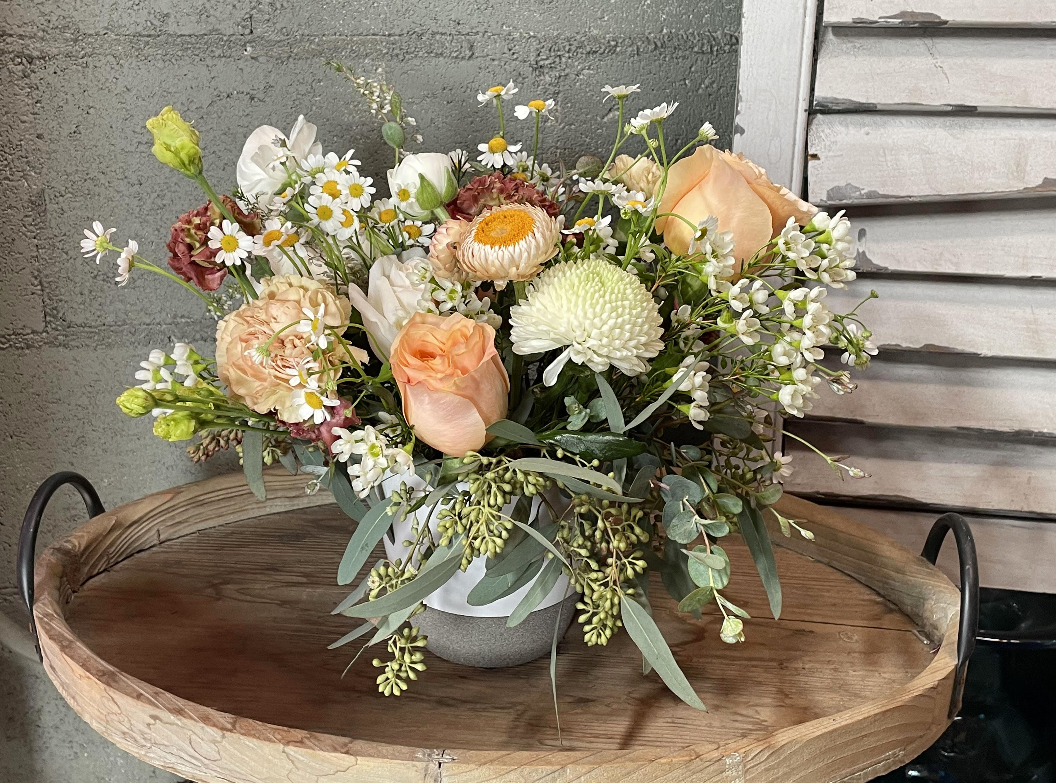 Mrs. Goose  - Cozy up with sweet chamomile, waxflower, peach roses, strawflower, and seasonal eucalyptus in a ceramic vase.  