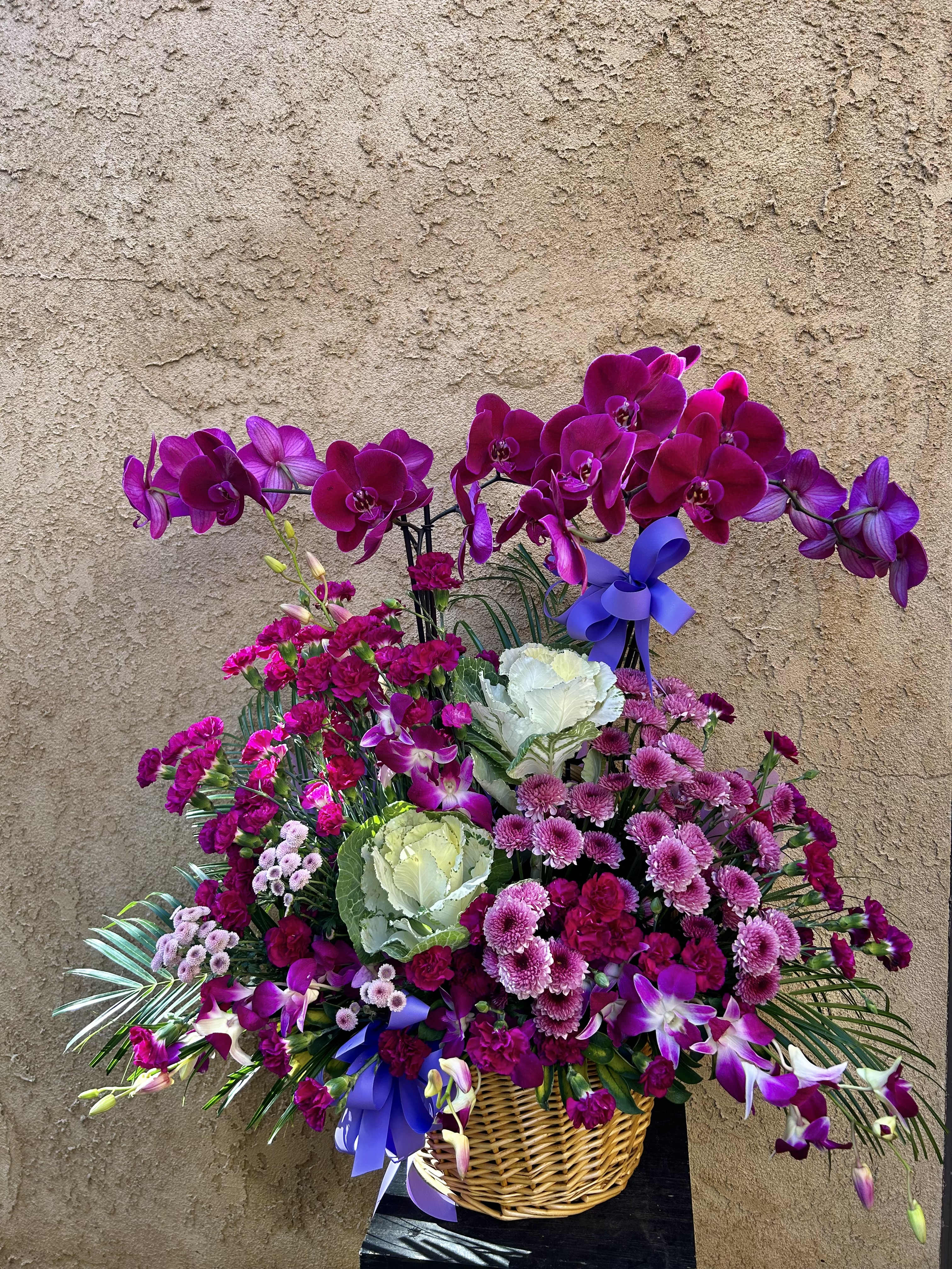 Basket of Purple Blends - Beautiful basket arrangement with orchids, chrysanthemums, carnations, and green accents.